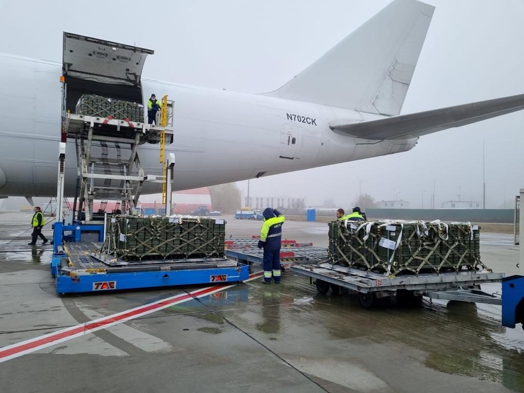 Workers unload a shipment of ammunition delivered as part of the United States of America's security assistance to Ukraine, at an airport outside Kyiv