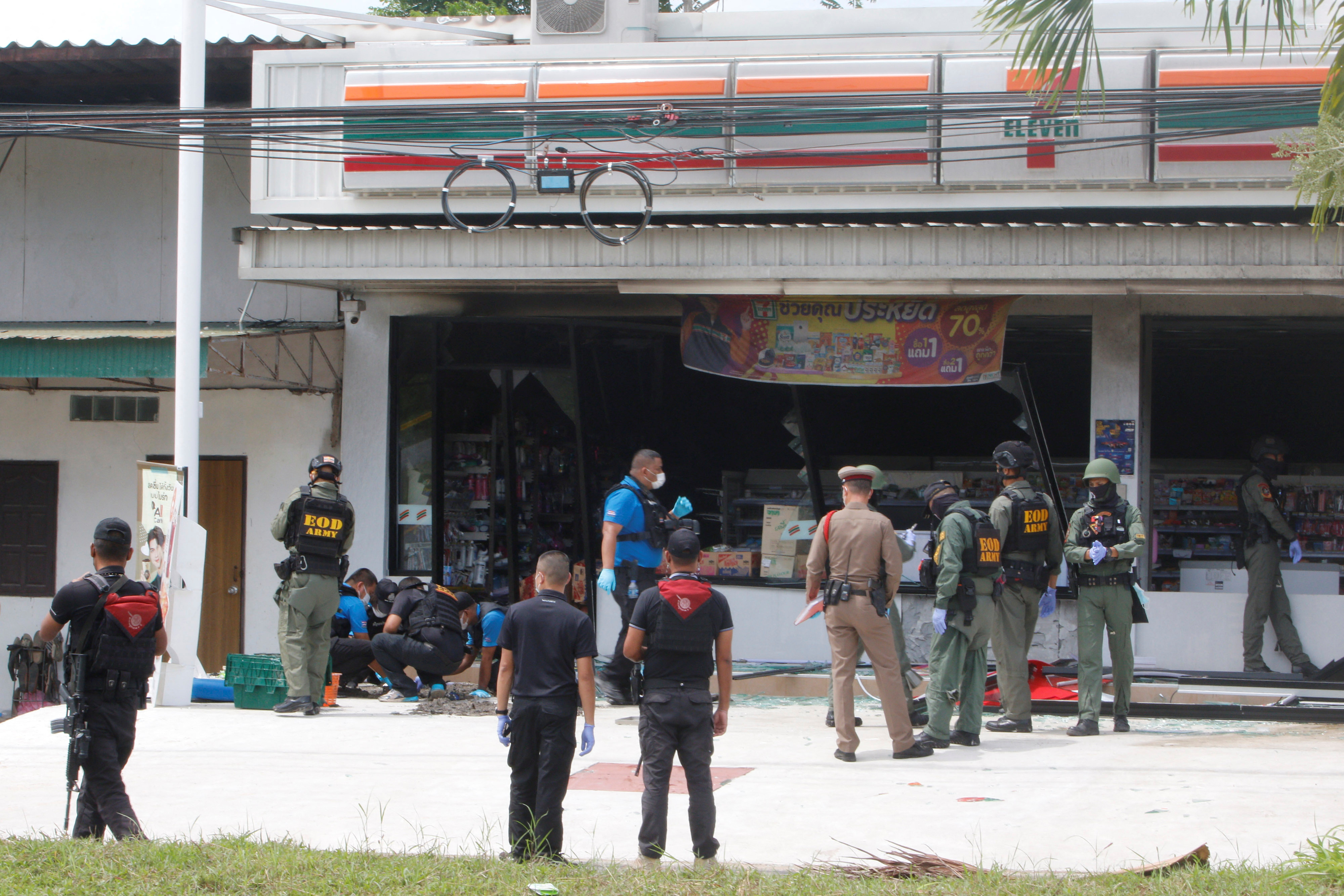 Emergency service members work in front of a shop after an explosion in Yala