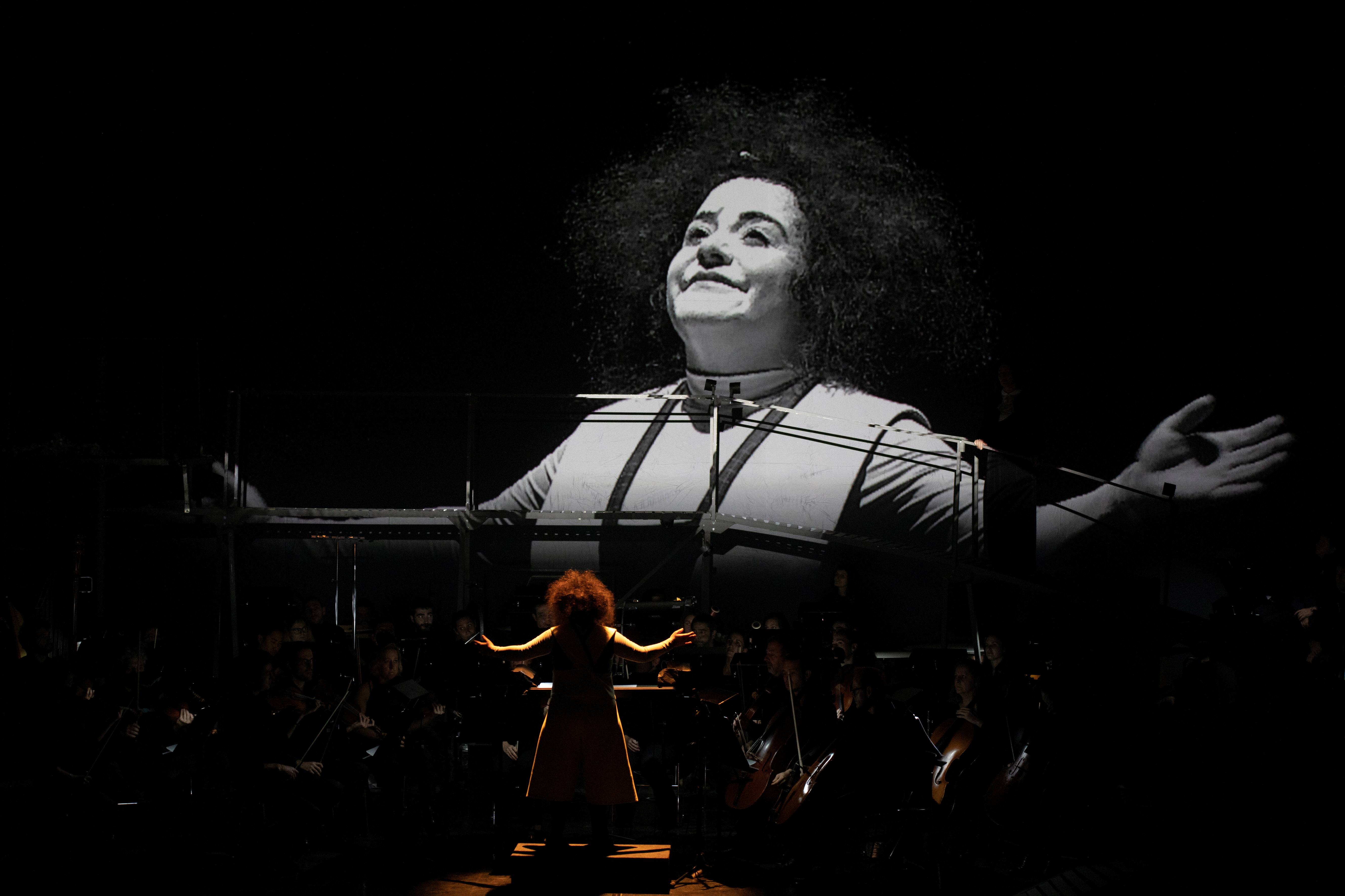 Clown performer Gabriela Munoz stands in front of the GIO Symphonia orchestra during a preview of 