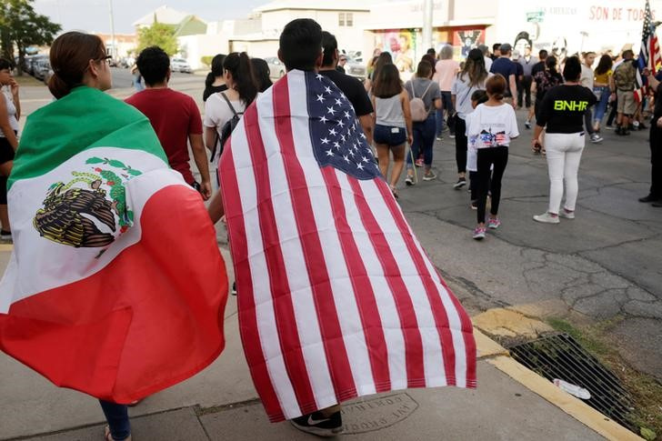 People with the Mexican flag and the U.S. flag take part in a rally against hate a day after a mass shooting at a Walmart store, in El Paso