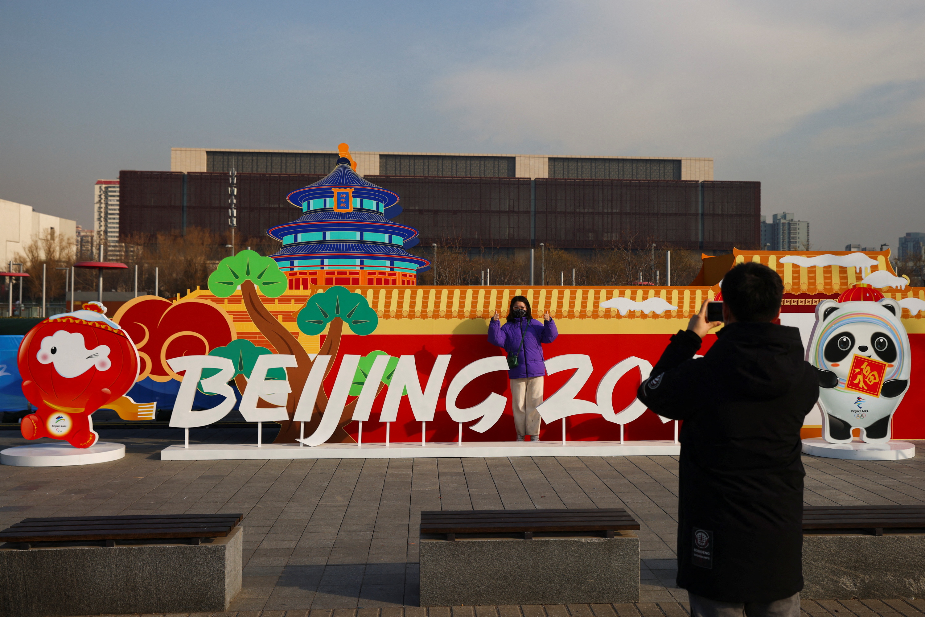 A woman has her picture taken in front of a Beijing 2022 installation near the closed loop 