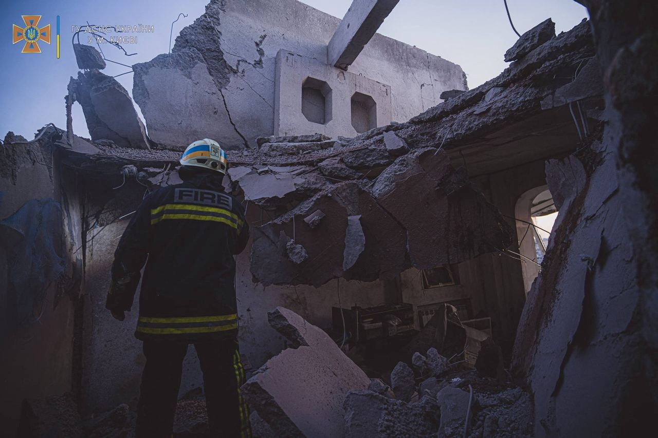 A rescuer works at a site of a residential building damaged by an airstrike in Kyiv