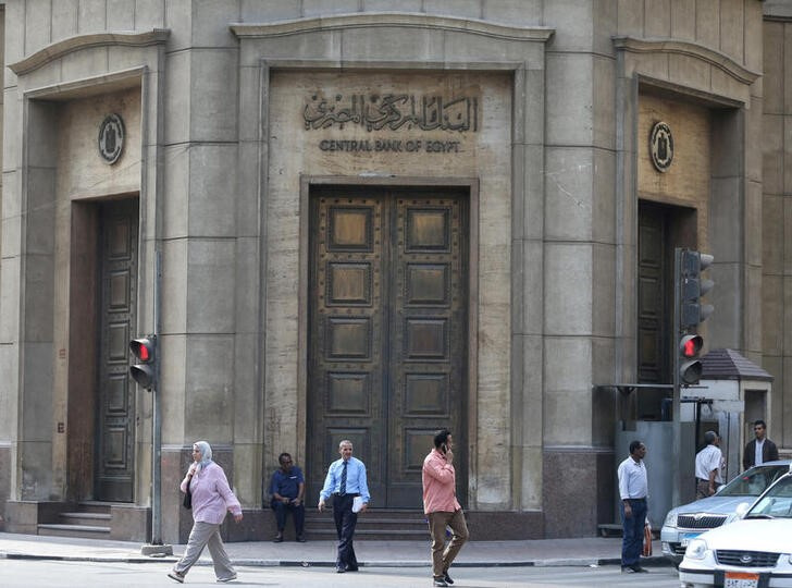 People walk in front of the Central Bank of Egypt's headquarters at downtown Cairo