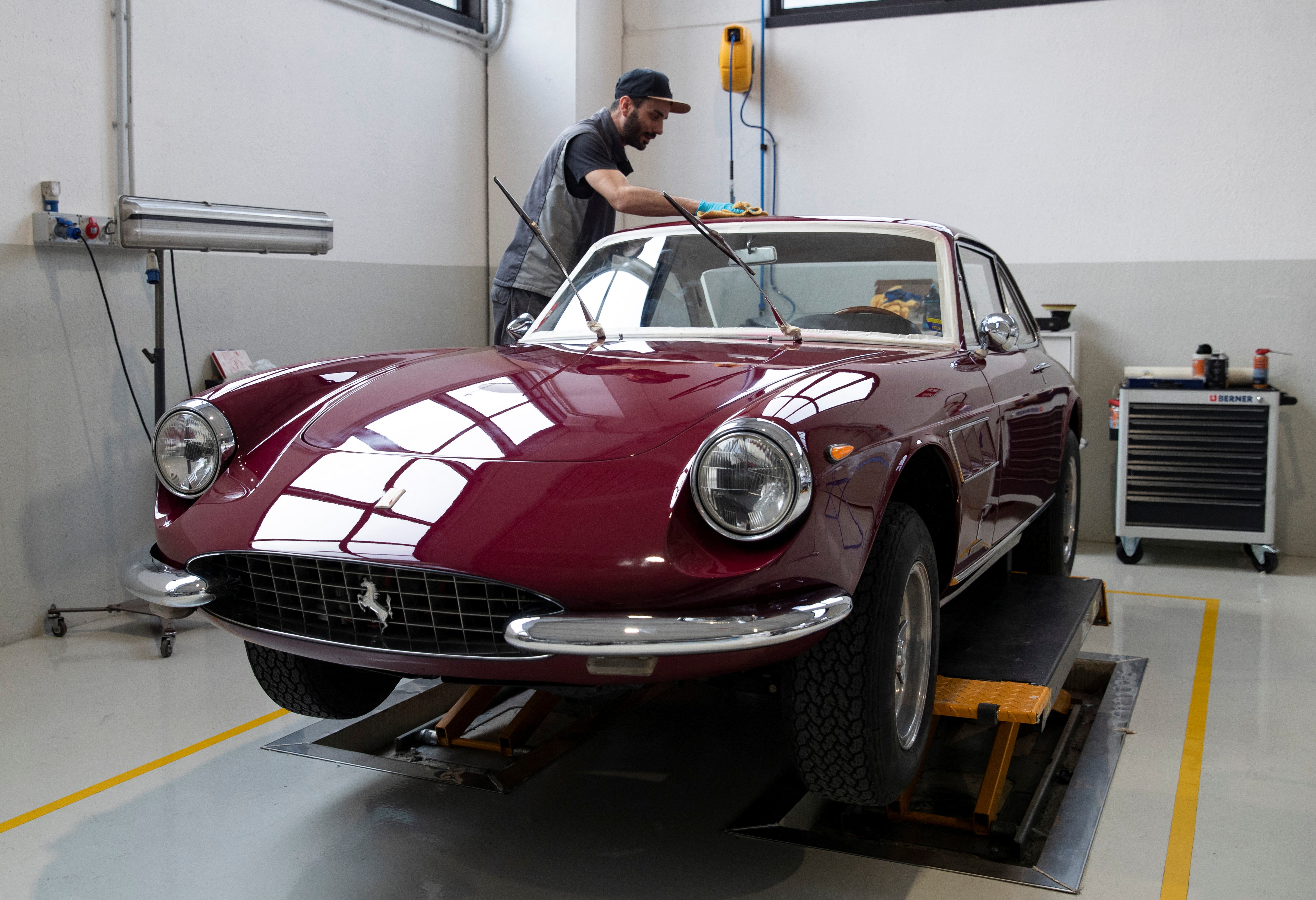 A man works on a Ferrari Classiche car at the Atelier Fiorano, a Rossocorsa authorised bodyshop in Assago