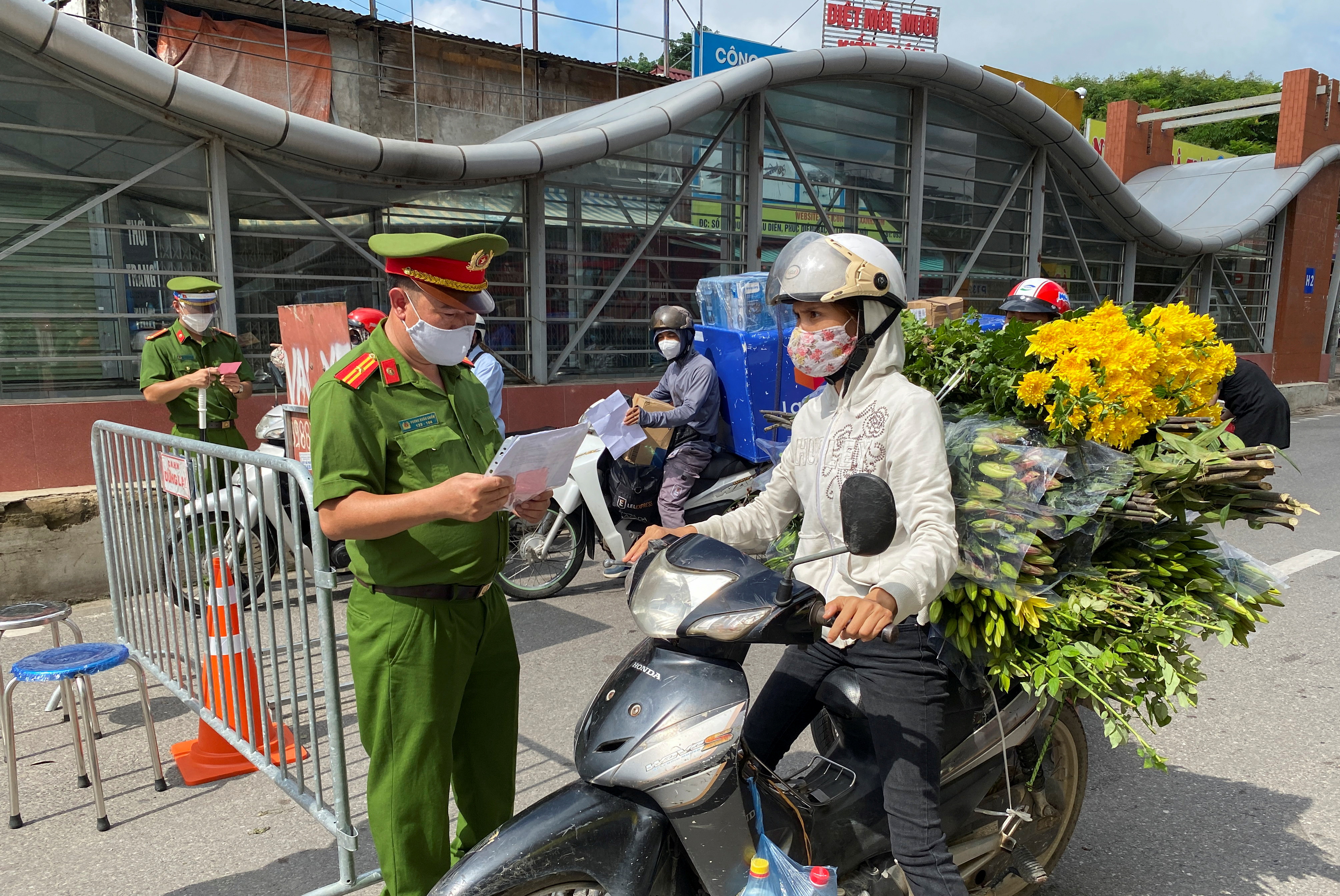 Vietnam police officers inspect commuters at a check point during the first day of the extended lockdown in Hanoi