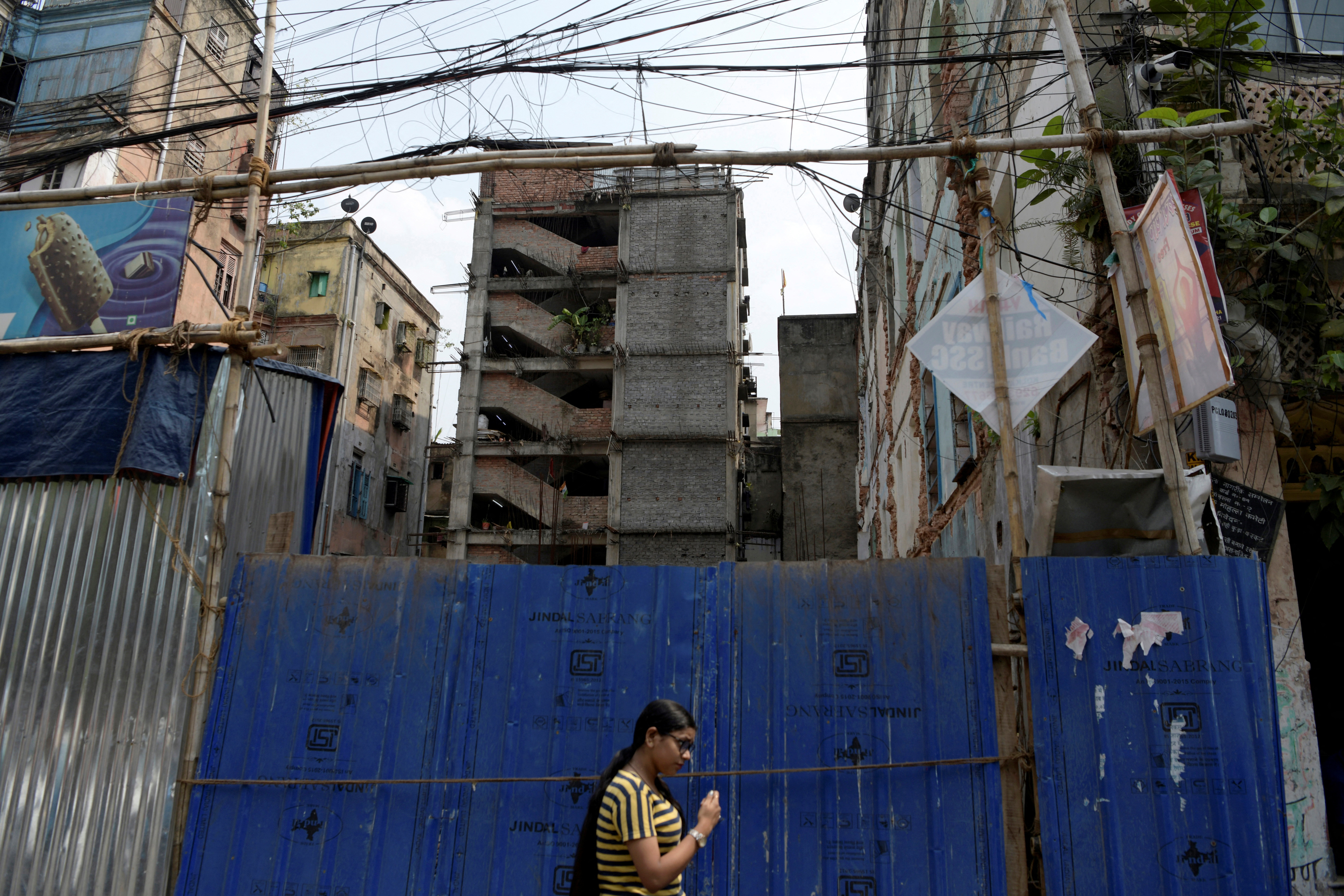 A woman passes by a house under construction in Kolkata.