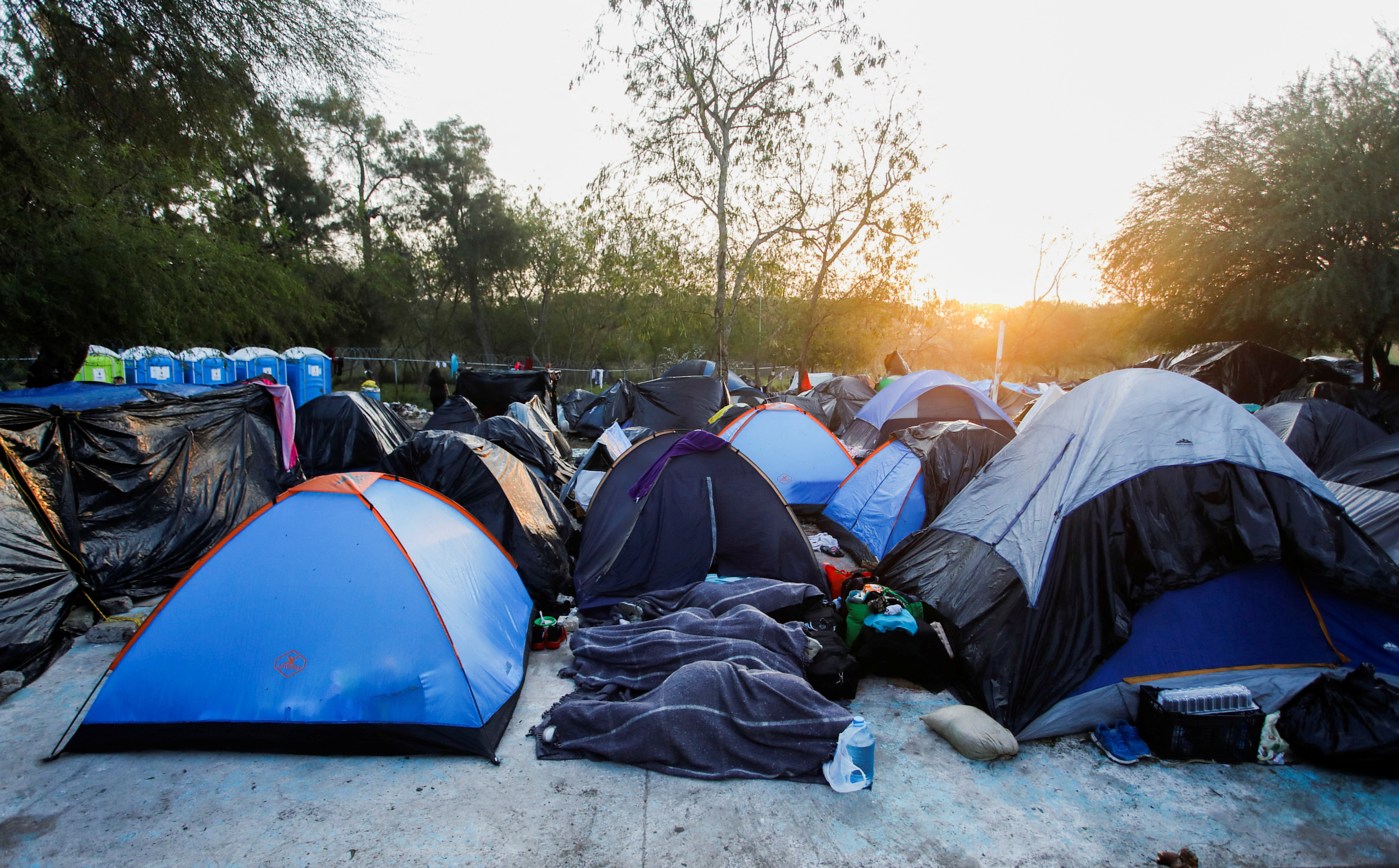 Migrants seeking asylum in the United States wait at a makeshift encampment, in Matamoros
