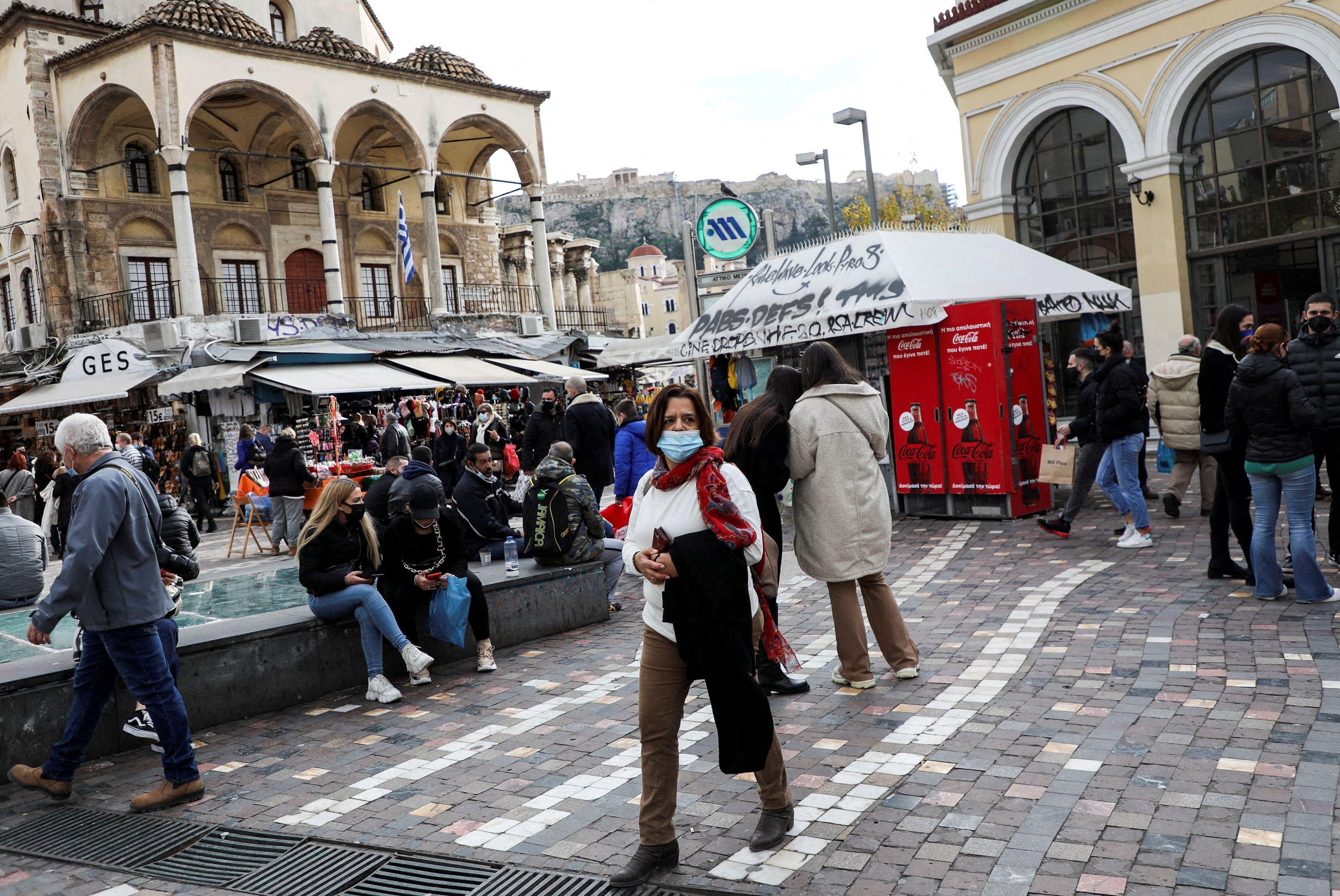 People wearing protective face masks make their way to Monastiraki square