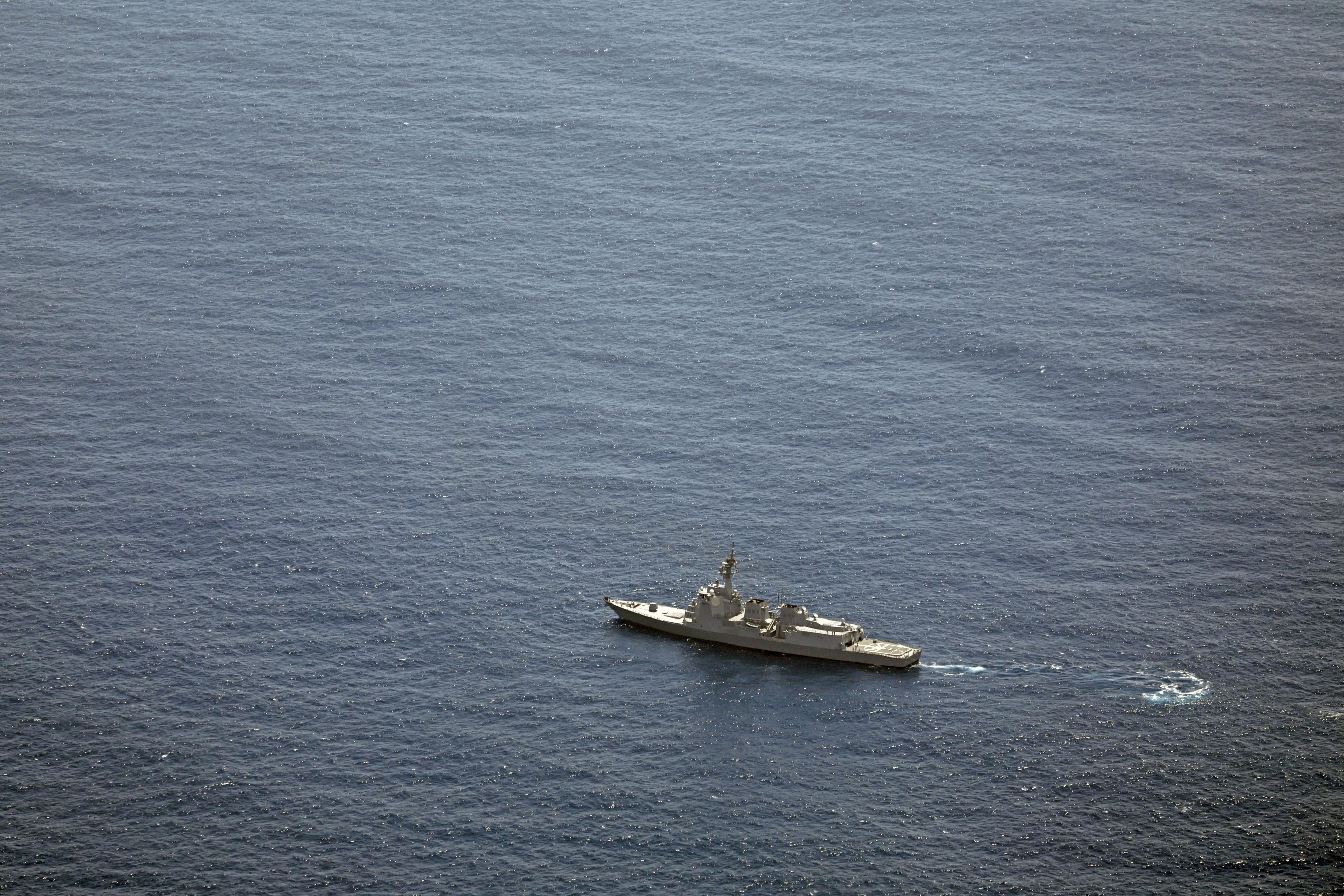 A Japan Maritime Self-Defense Force (JMSDF) vessel conducts a search and rescue operation at the site where two JMSDF helicopters crashed into the sea near Torishima
