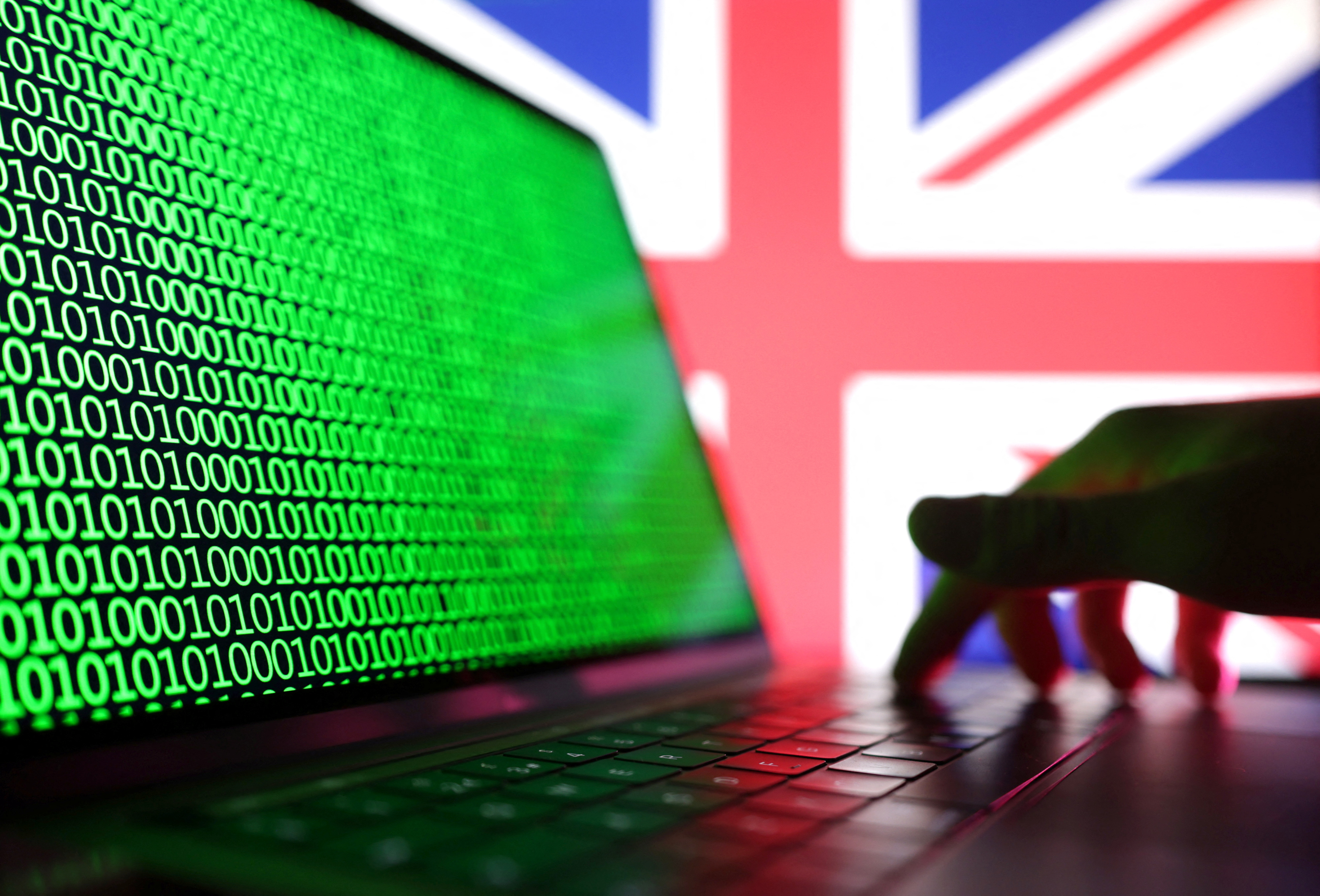 Illustration shows a laptop with binary codes displayed in front of the UK flag