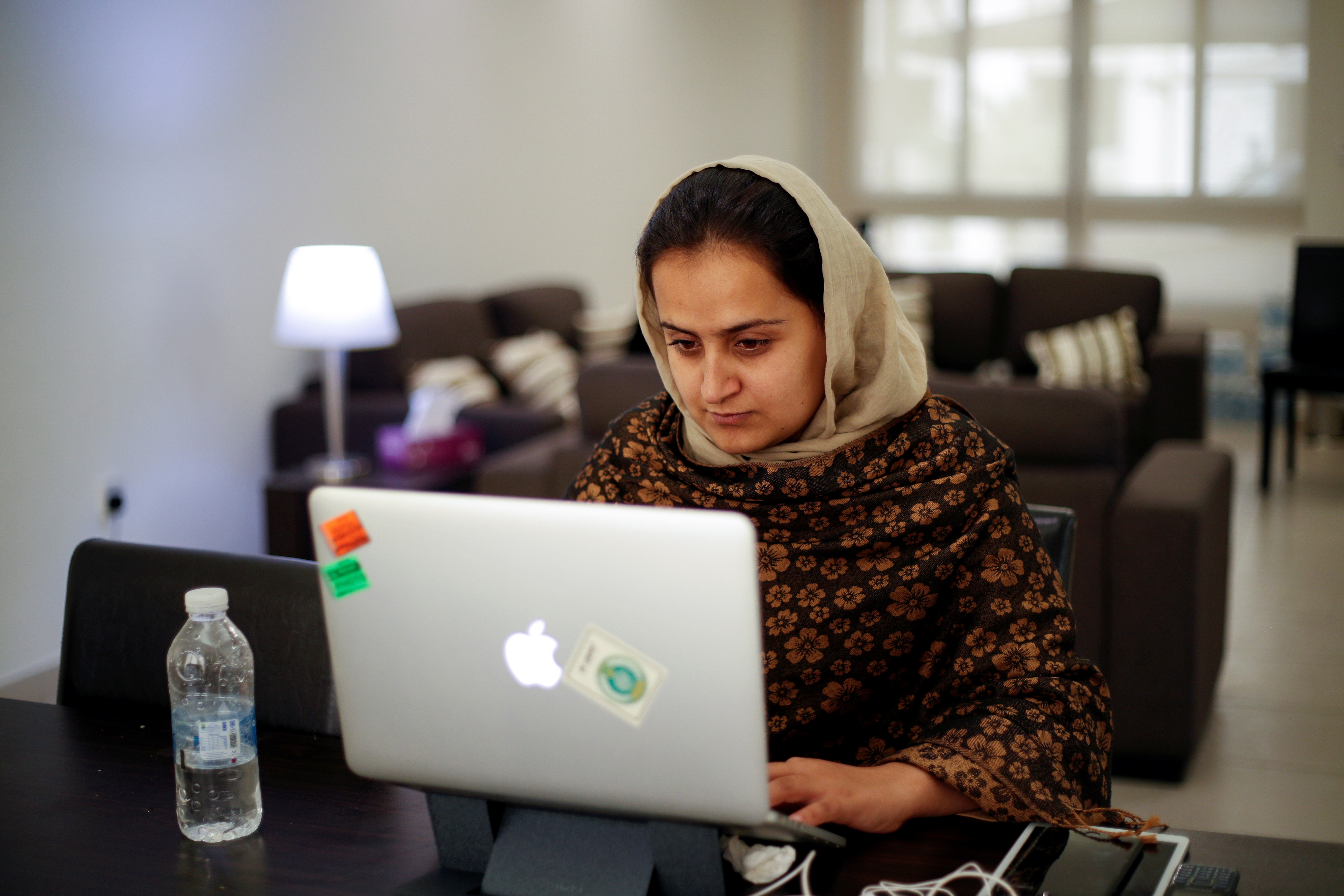 Afghan news anchor Beheshta Arghand works on laptop at a temporary residence compound in Doha