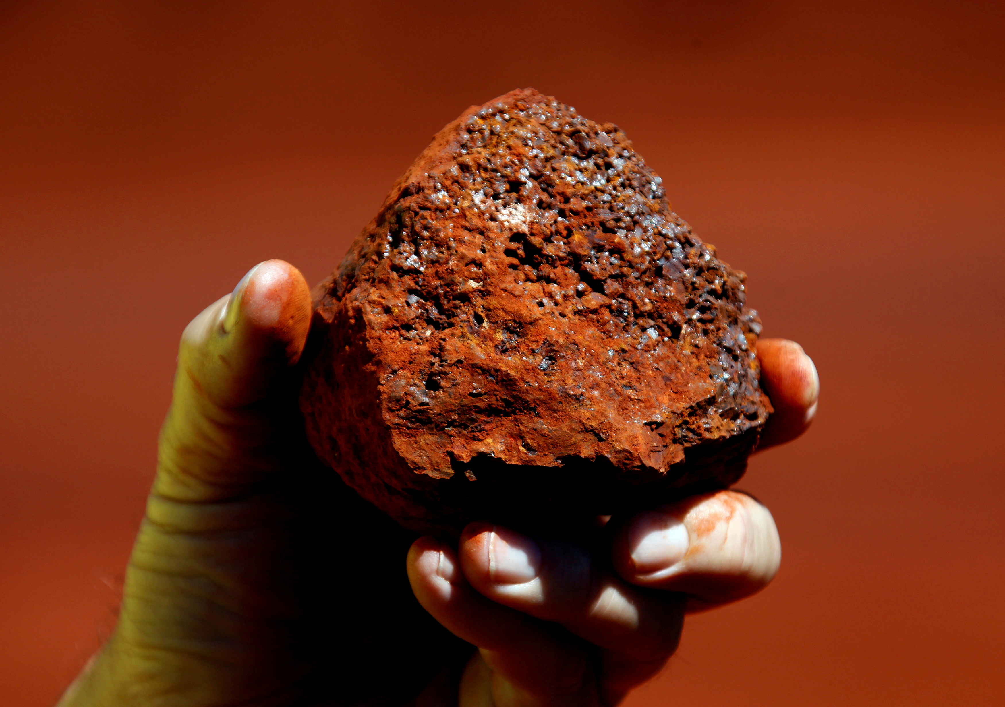 A miner holds a lump of iron ore at a mine located in the Pilbara region of Western Australia December 2, 2013. REUTERS/David Gray/File Photo