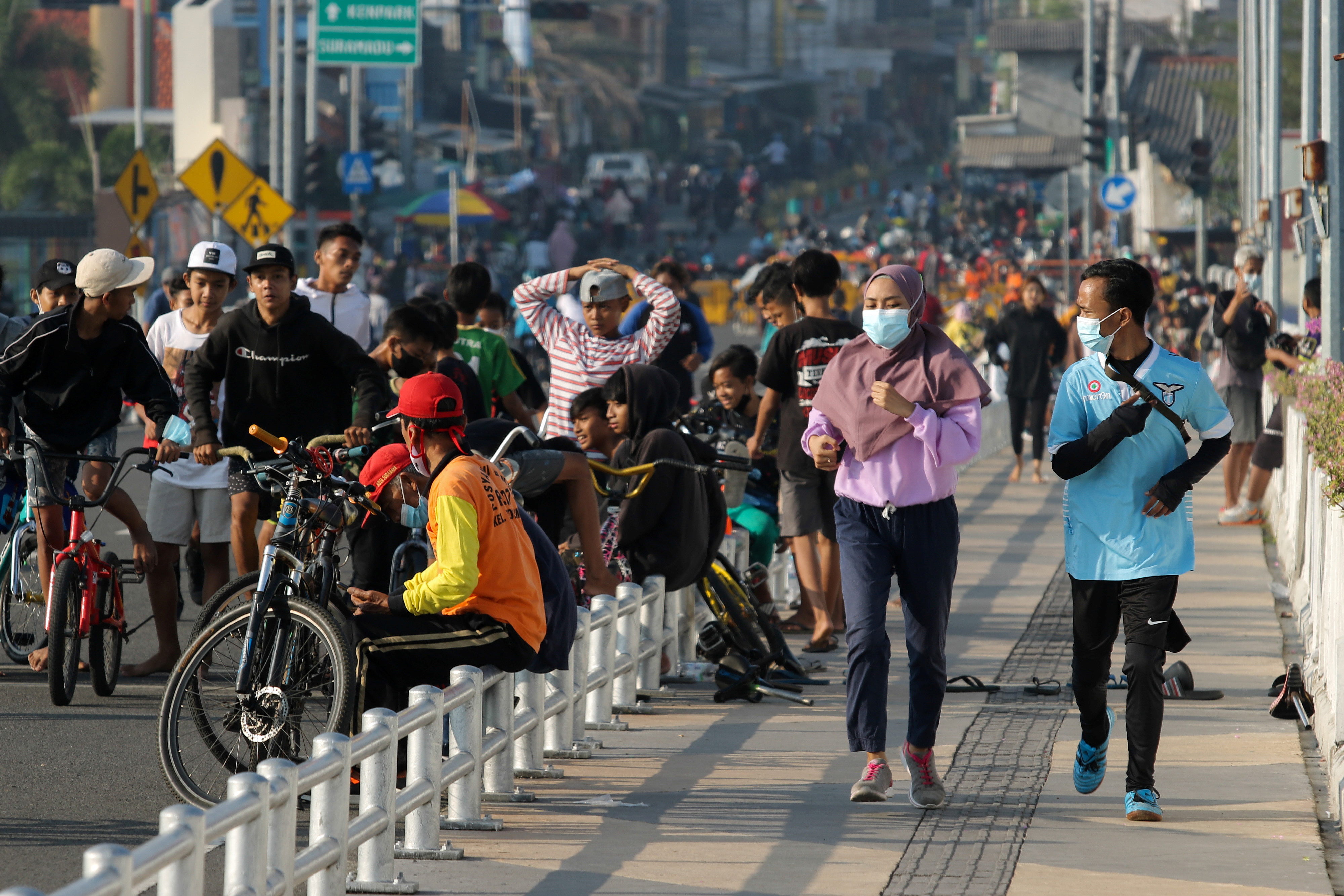 People exercise at a bridge area in Surabaya