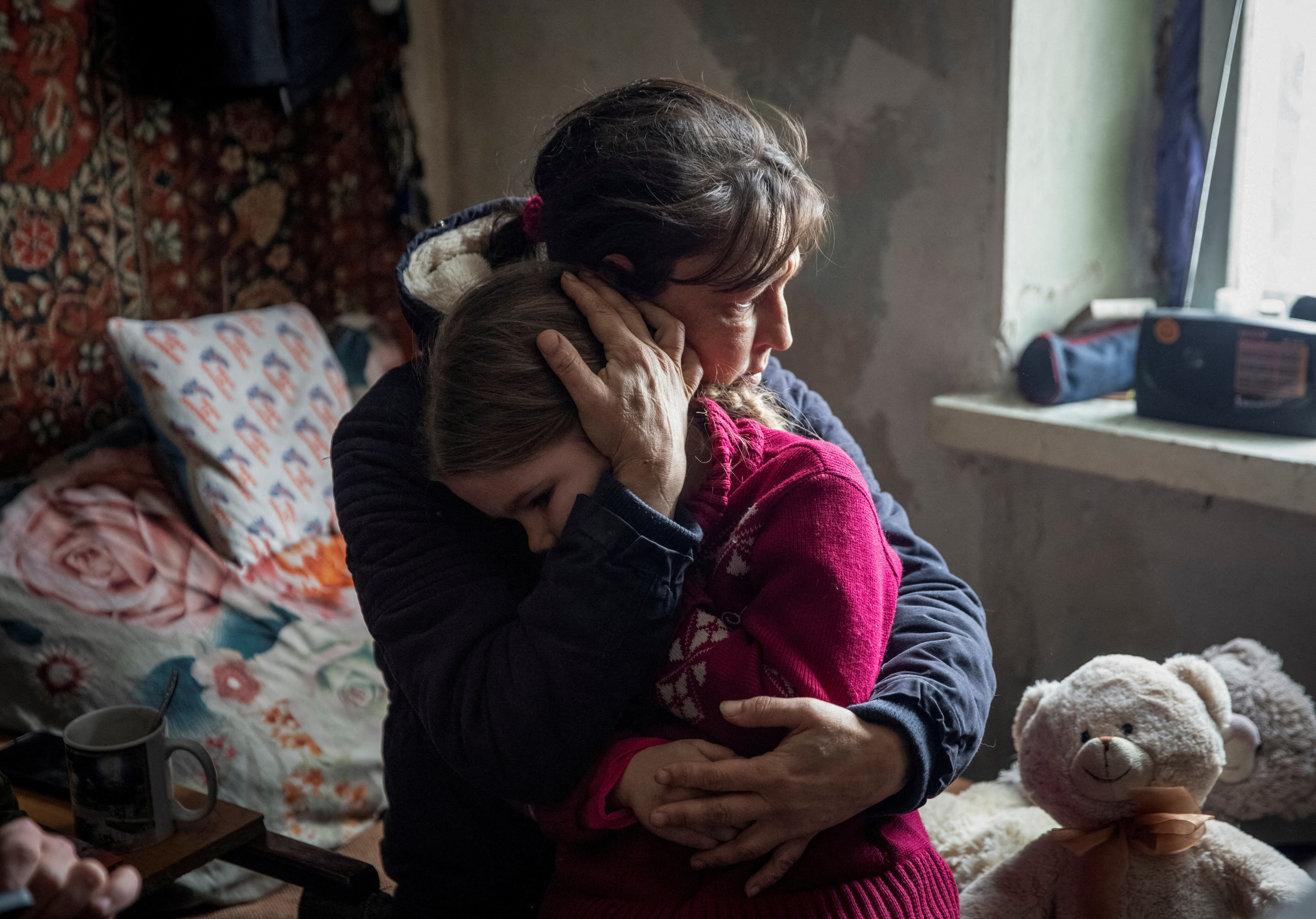 A grandmother hugs her granddaughter Arina before evacuation from front line city of Bakhmut