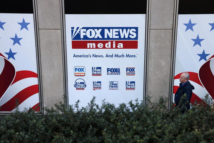 A person walks by Fox News signage posted on the News Corporation building in New York City