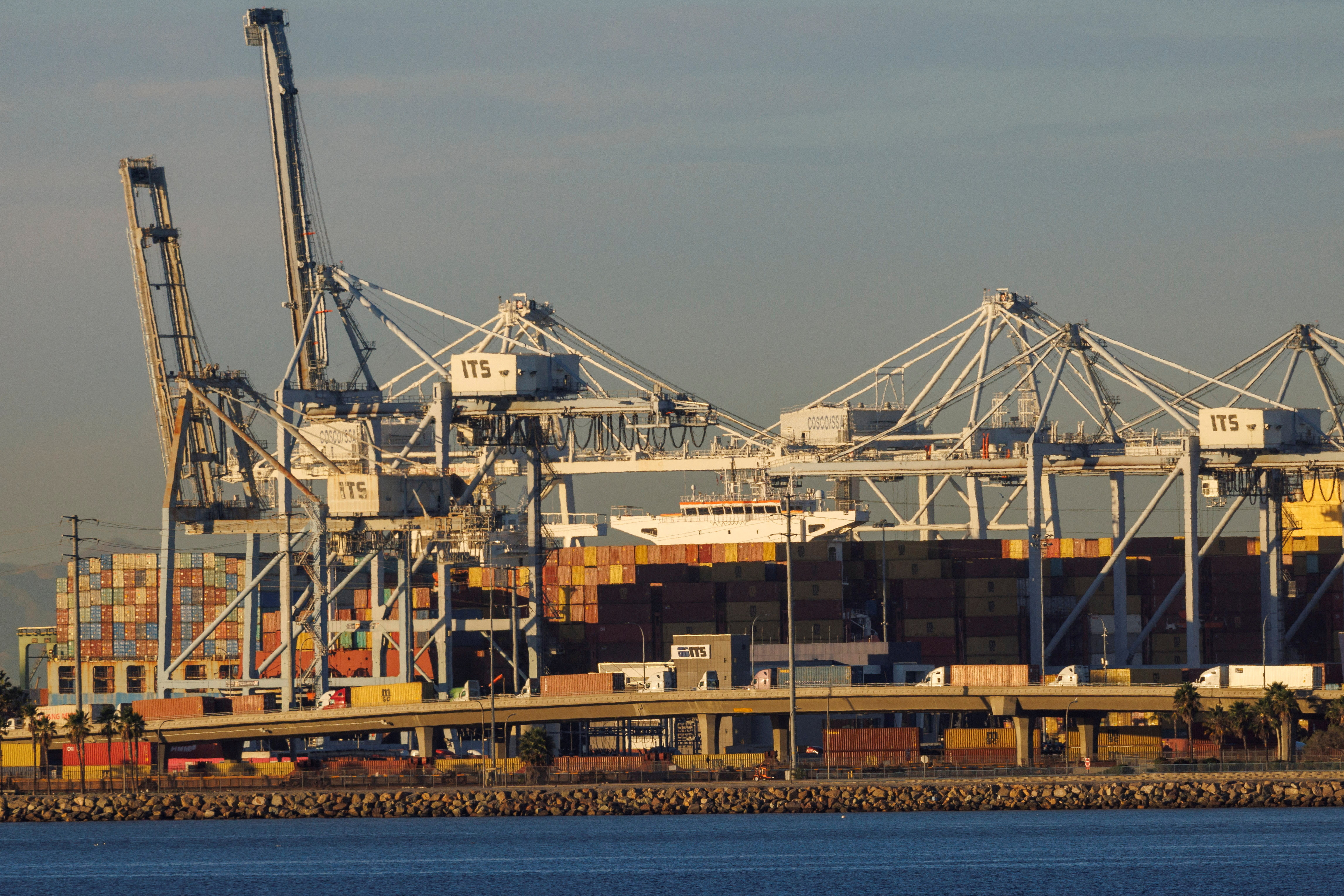 Container trucks , ships and cranes are shown at the Port of Long Beach. California
