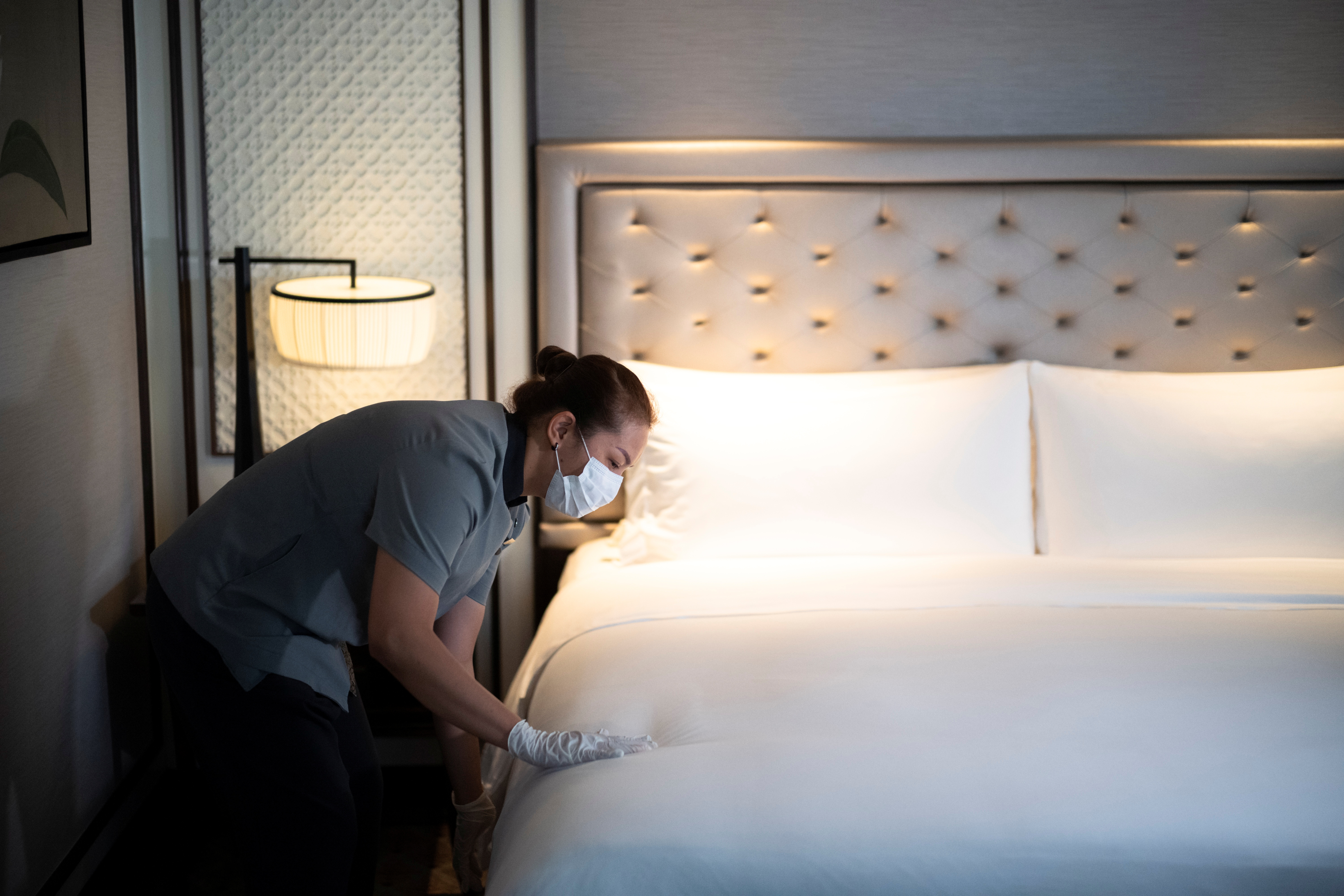 A hotel worker cleans a bed as a precaution against the coronavirus disease (COVID-19) at Athenee Hotel in Bangkok, Thailand, November 22, 2021. Picture taken November 22, 2021. REUTERS/Athit Perawongmetha