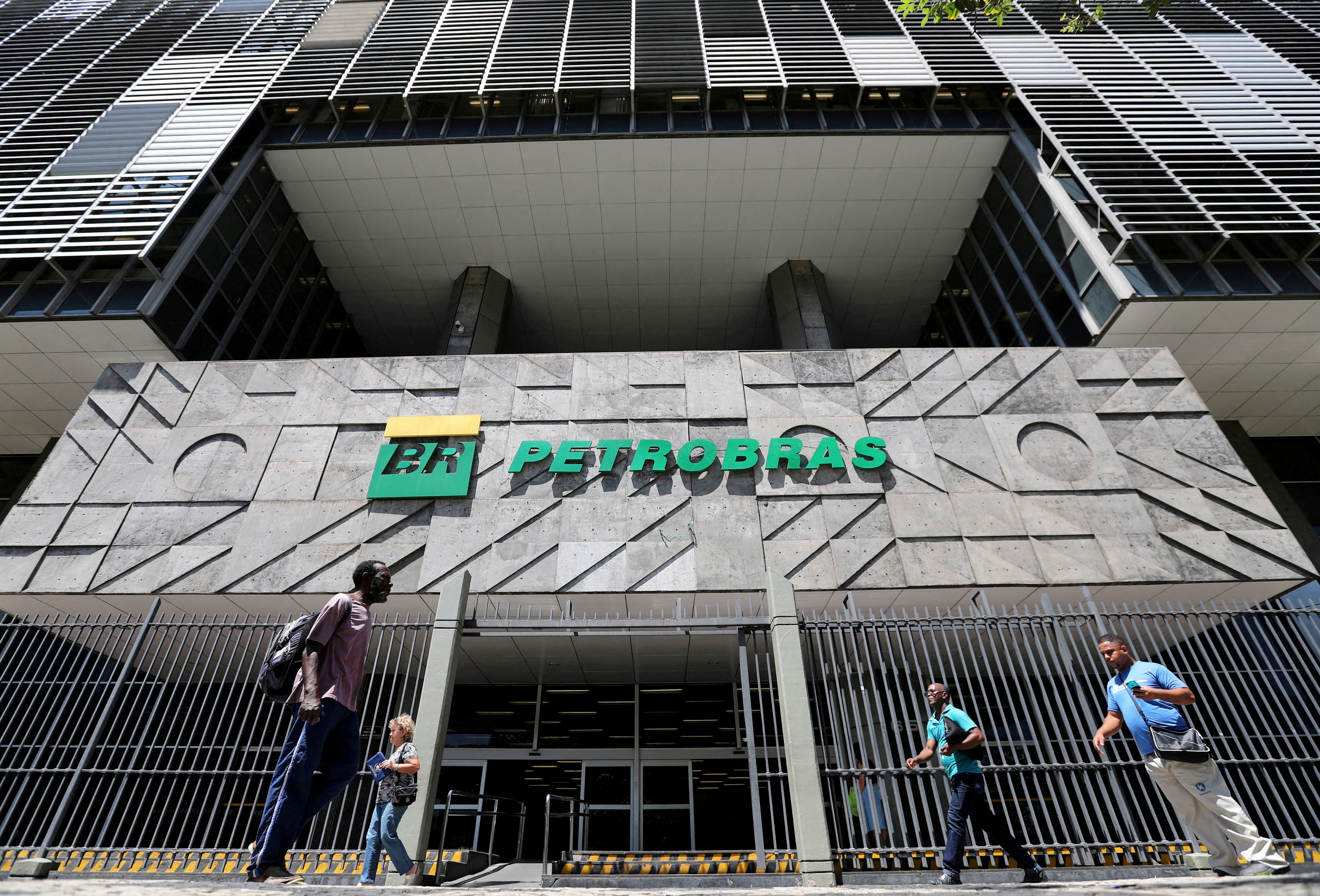 People walk in front of the headquarters of Petrobas in Rio de Janeiro