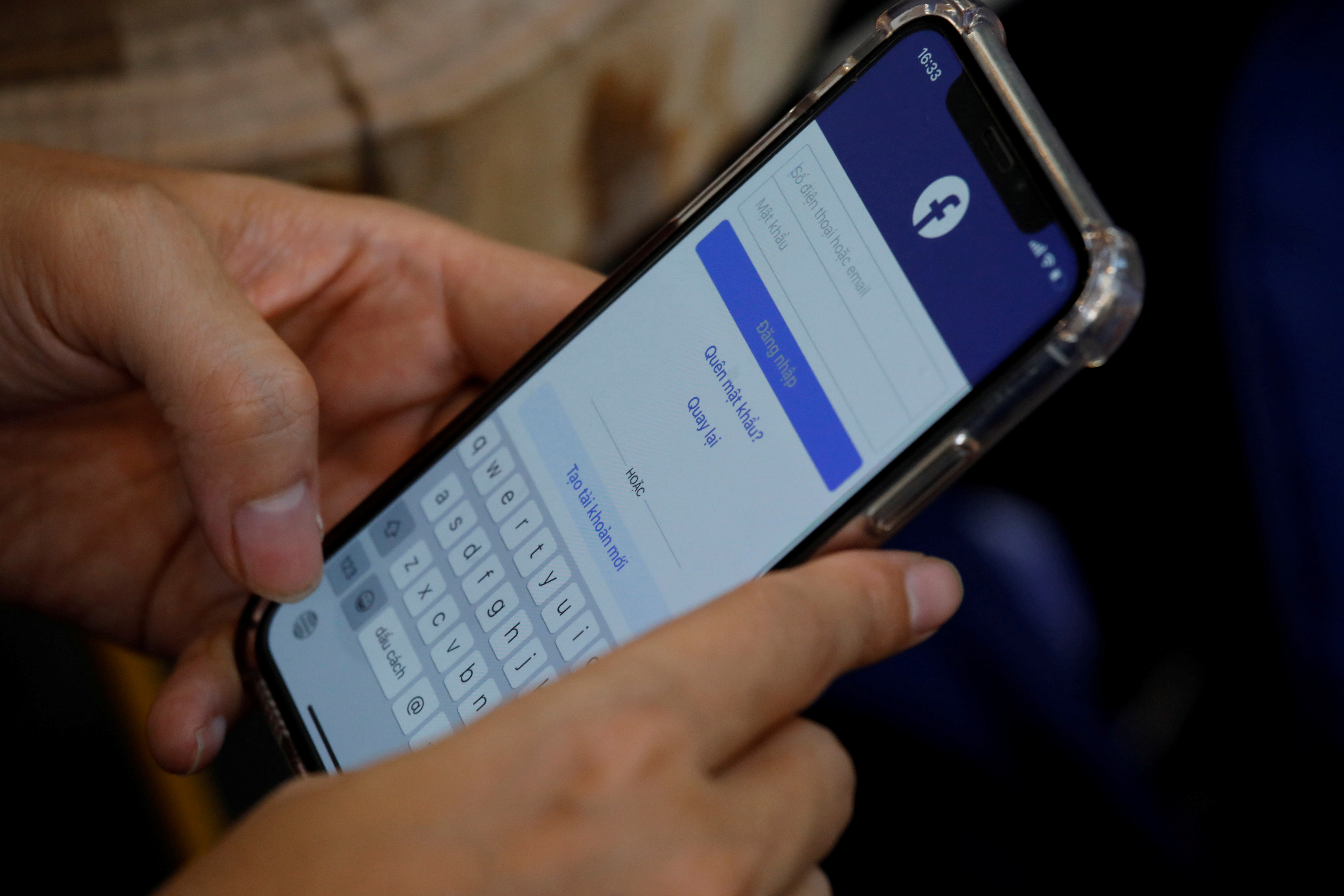 A Facebook user logs in on his mobile at a cafe in Hanoi