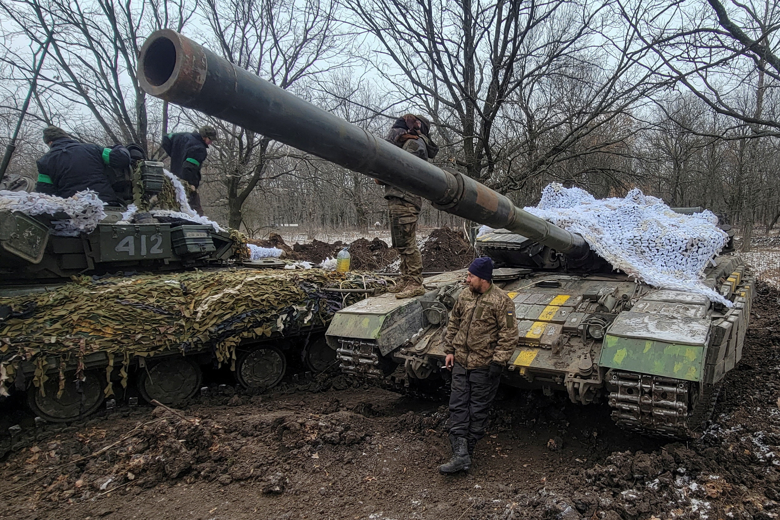 Ukrainian servicemen stand n on their tanks near the frontline town of Bakhmut