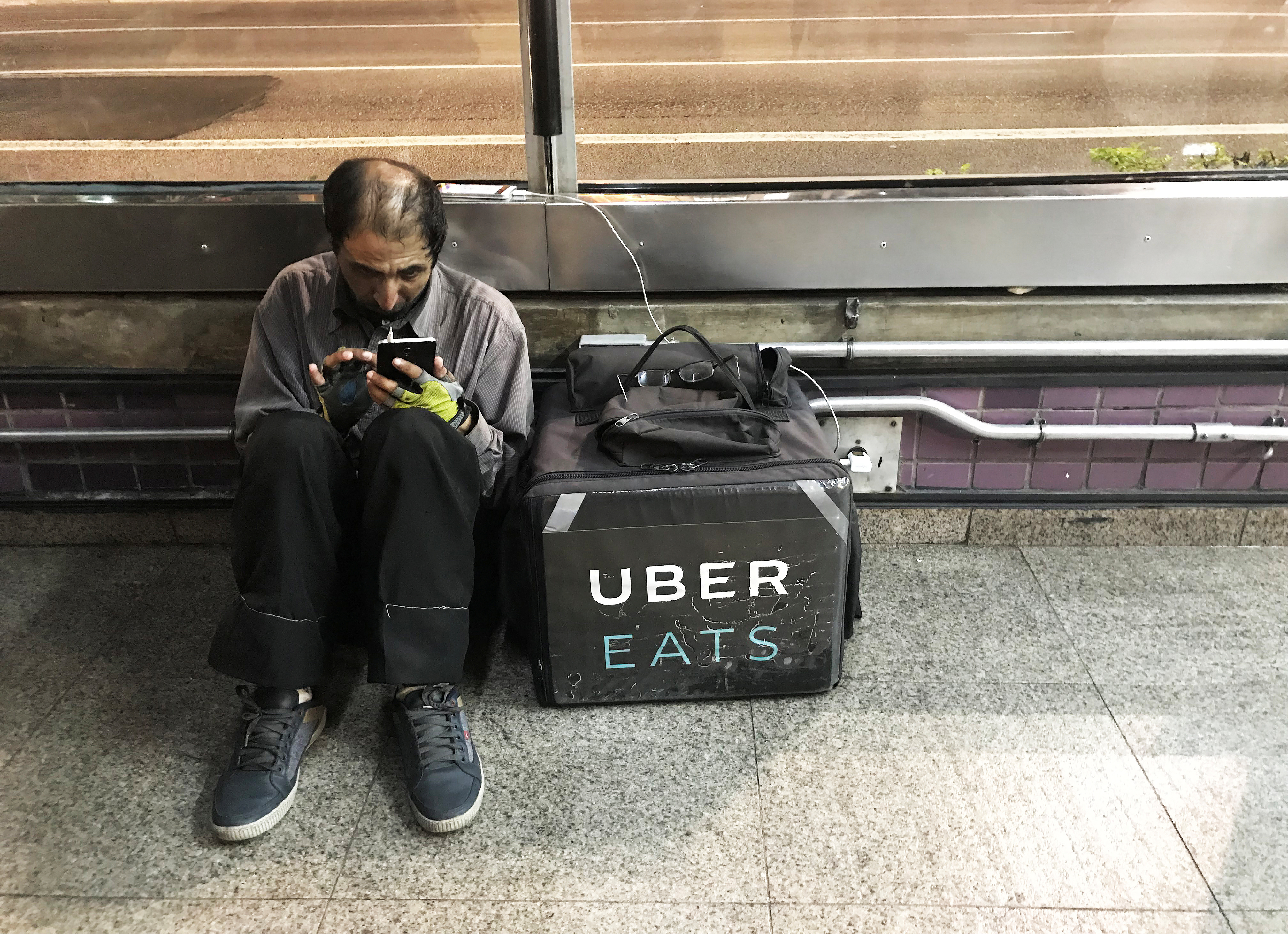 An Uber Eats worker checks his mobile phone in Sao Paulo