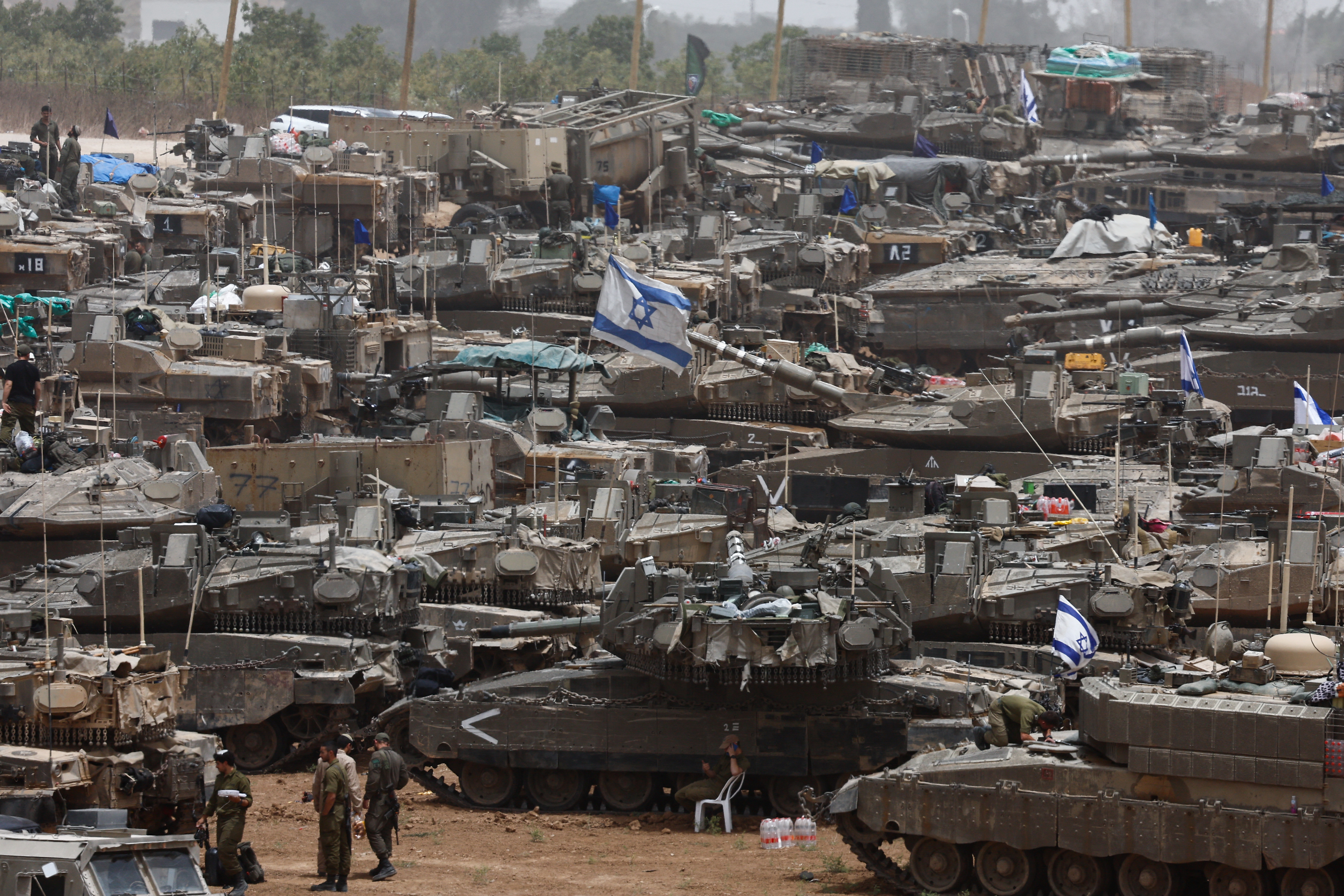 Israeli soldiers stand next to military vehicles, near the border with Gaza, in Israel