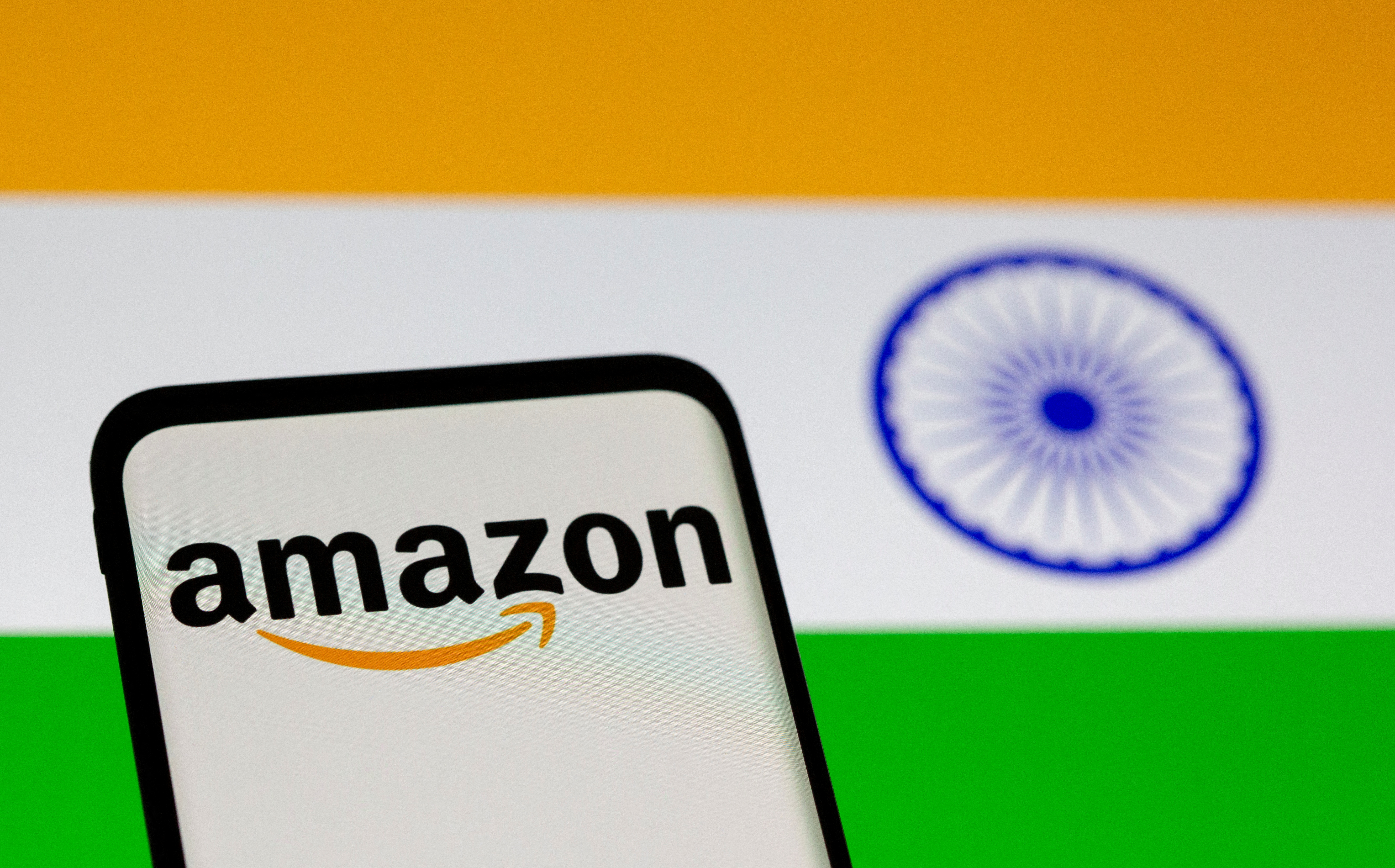 Smartphone with Amazon logo is seen in front of displayed Indian flag in this illustration taken