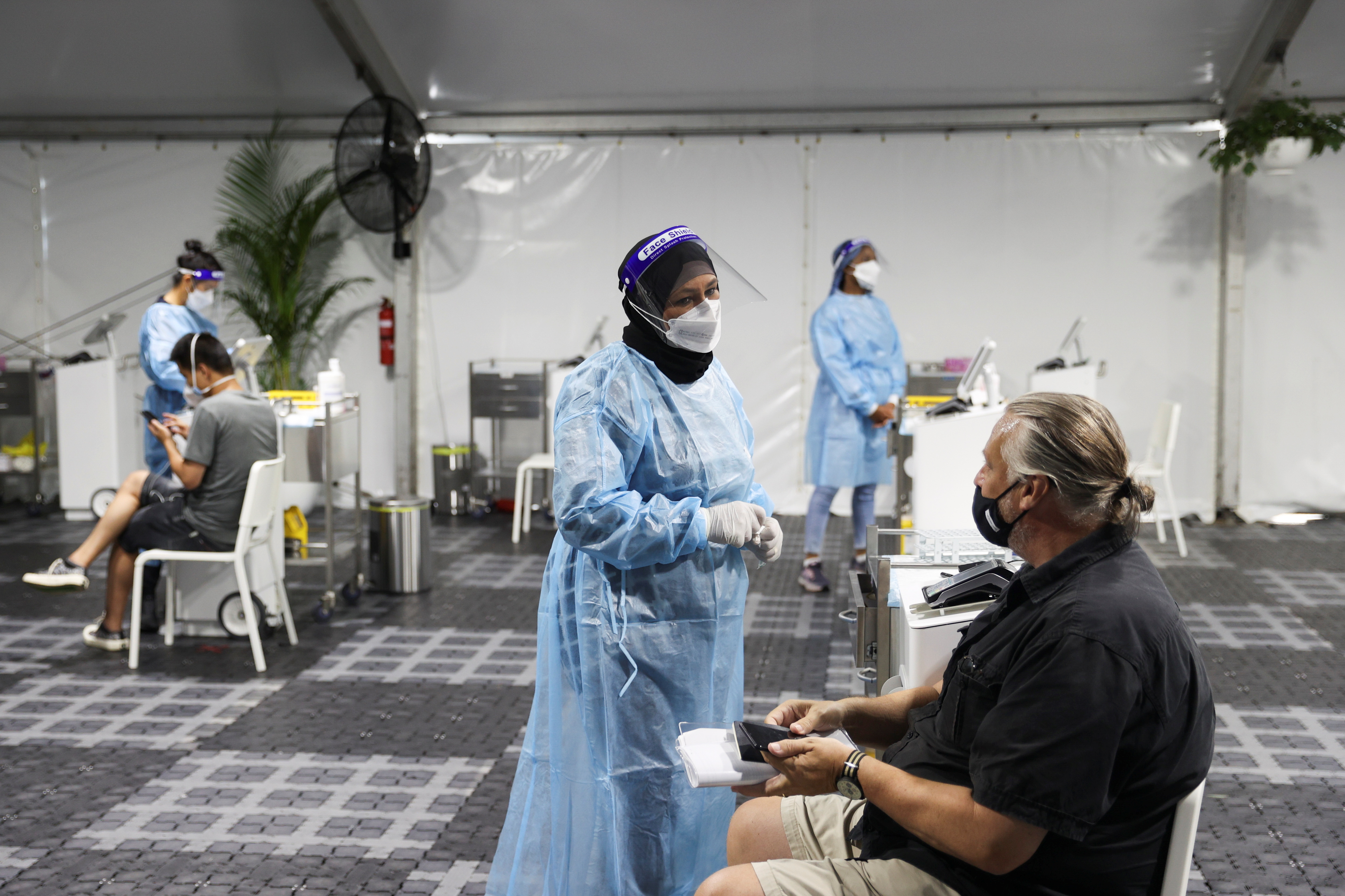 Travellers receive tests for the coronavirus disease (COVID-19) at a pre-departure testing facility, as countries react to the new coronavirus Omicron variant, outside the international terminal at Sydney Airport in Sydney, Australia, November 29, 2021.  REUTERS/Loren Elliott