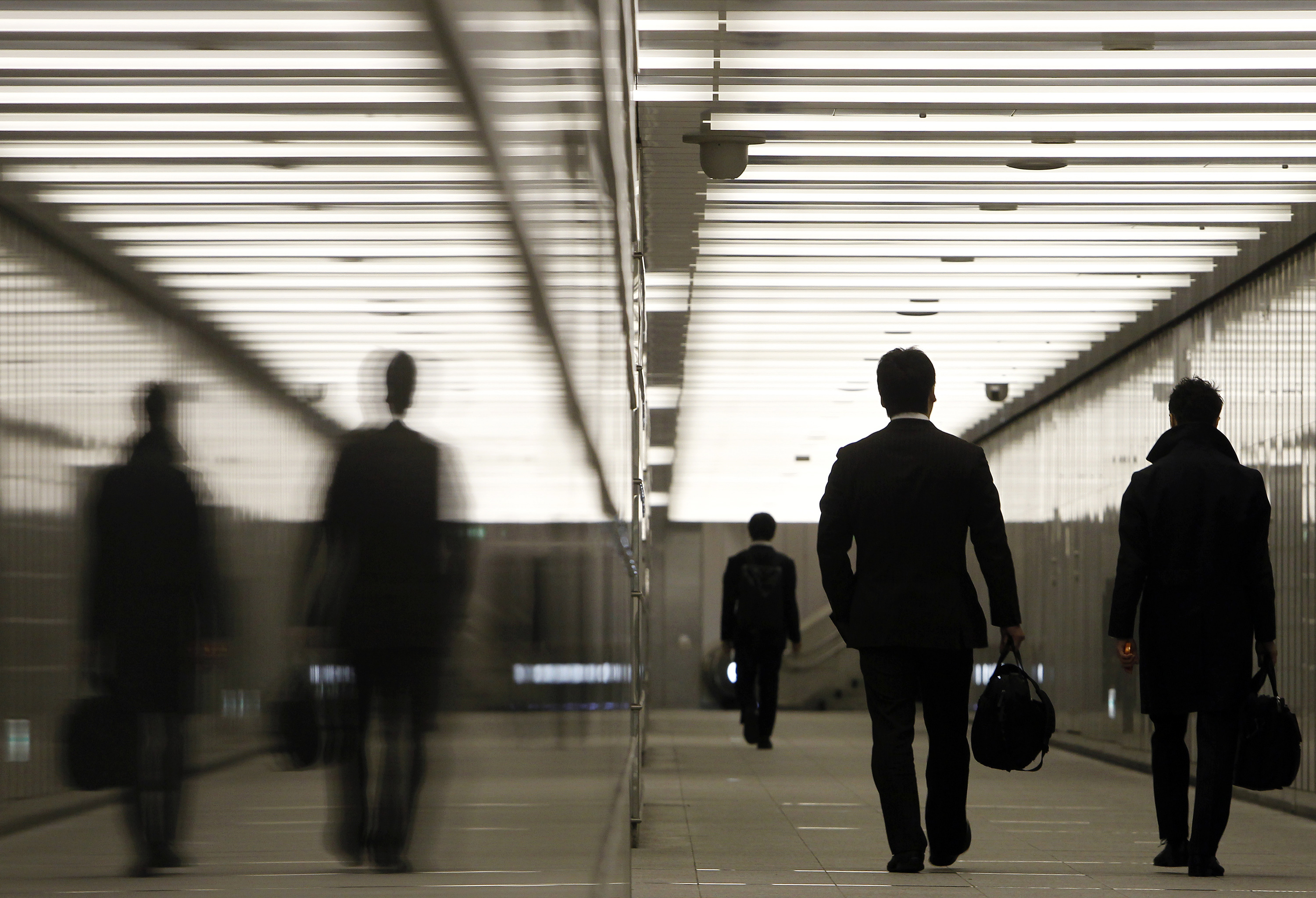 Businessmen walk through a business complex in Tokyo