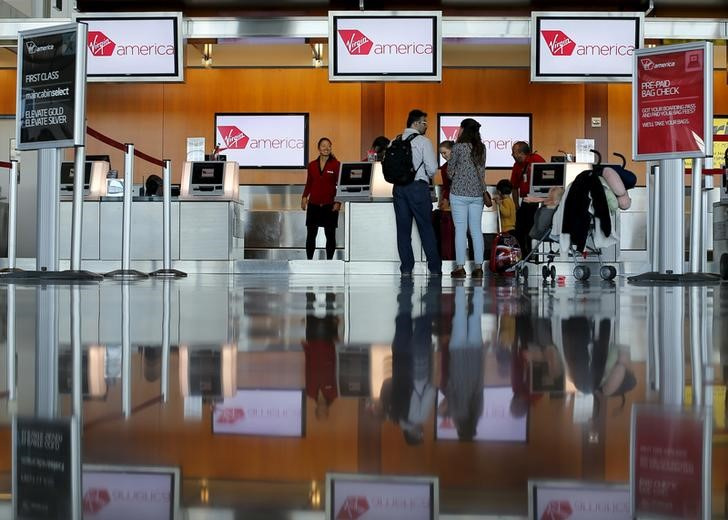 Passengers check in for their flights at the Virgin America ticket counter in San Diego, California