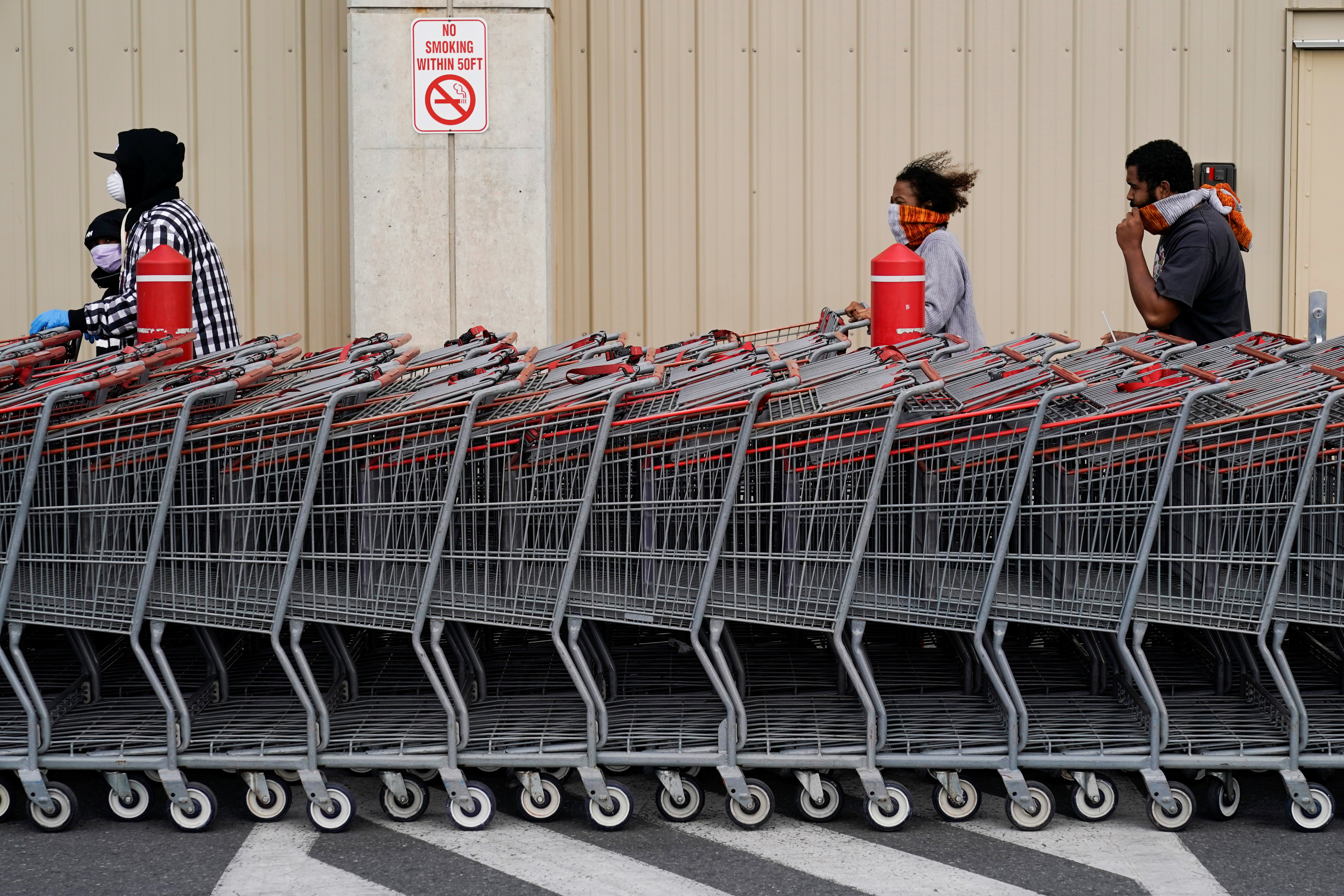 People wear masks as they wait to enter a Costco store during the outbreak of coronavirus in Washington