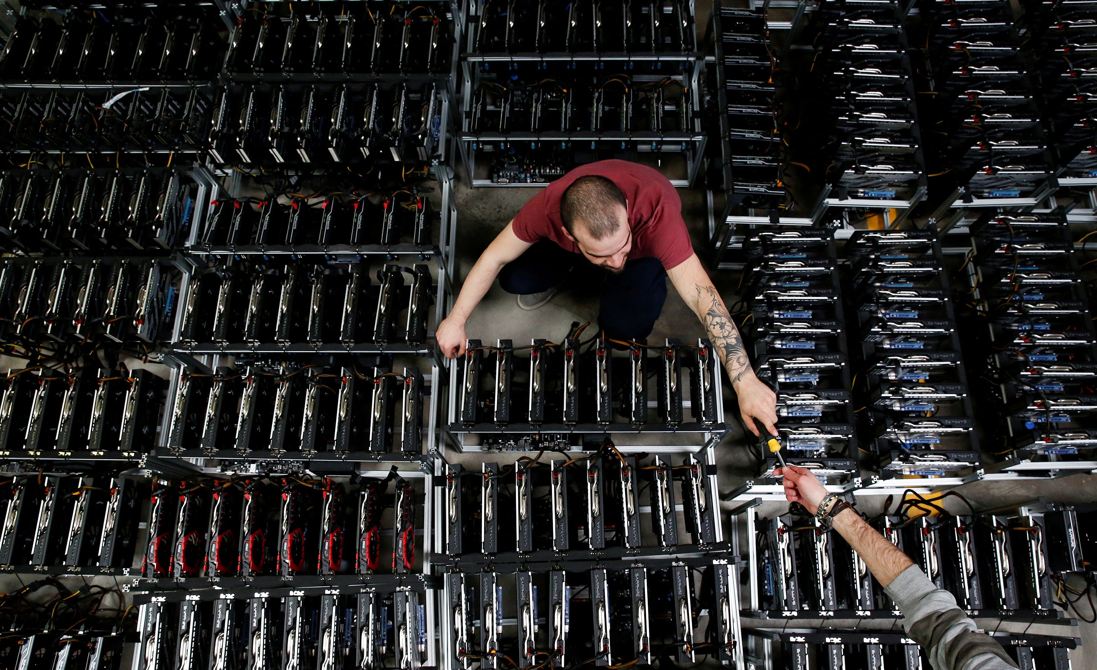 Employees work on bitcoin mining computers at Bitminer Factory in Florence