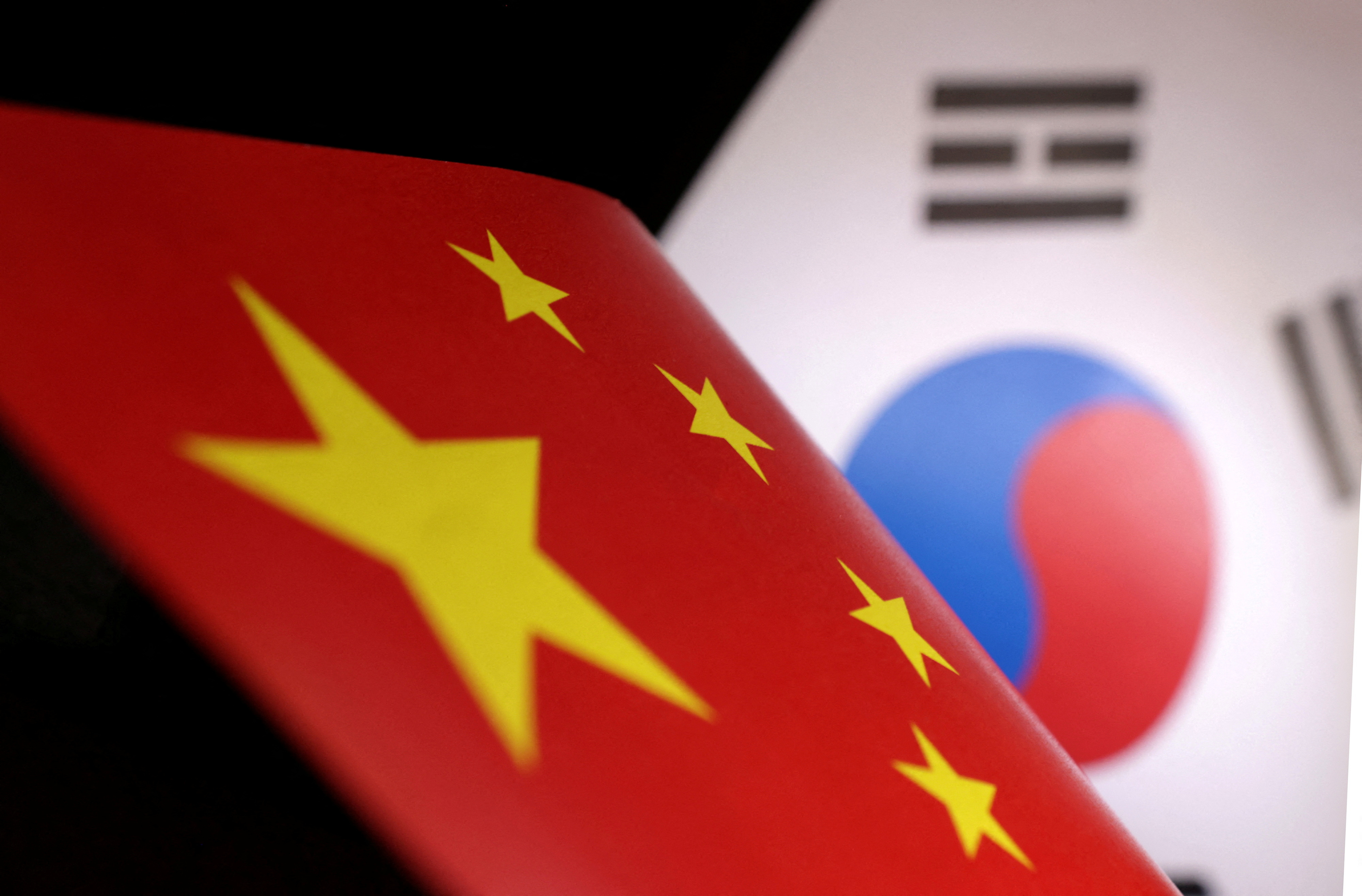 Illustration shows printed Chinese and South Korean flags