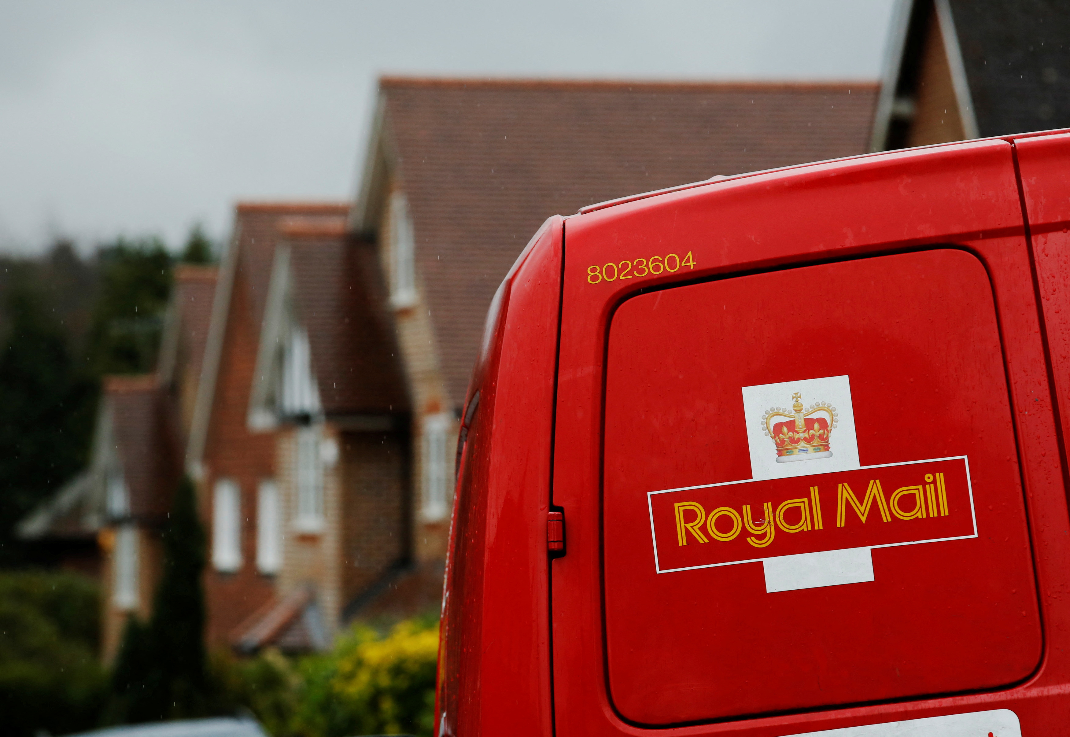 A Royal Mail postal van is parked outside homes in Maybury near Woking in southern England