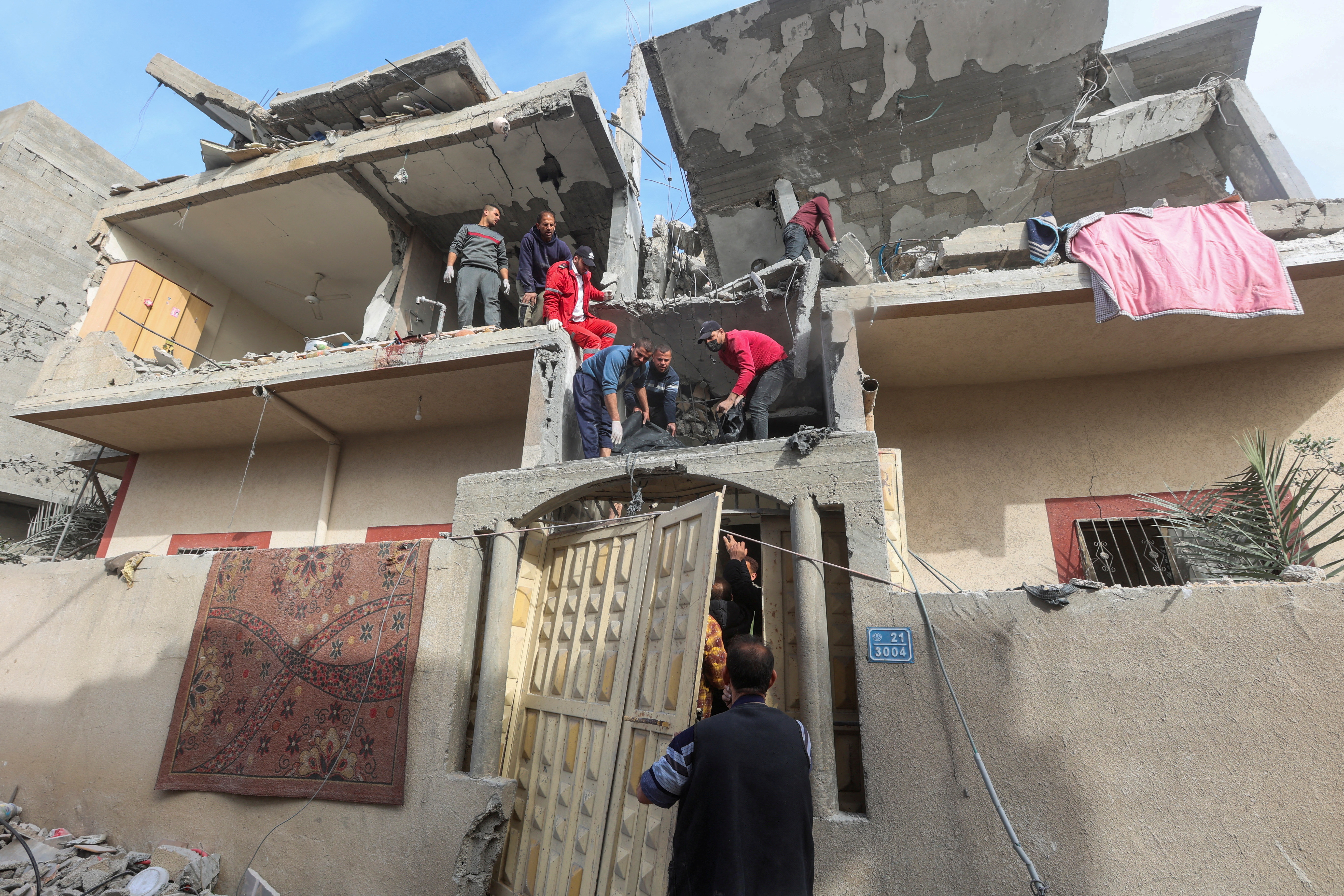Palestinians inspect the site of an Israeli strike on a house, in Rafah, in the southern Gaza Strip