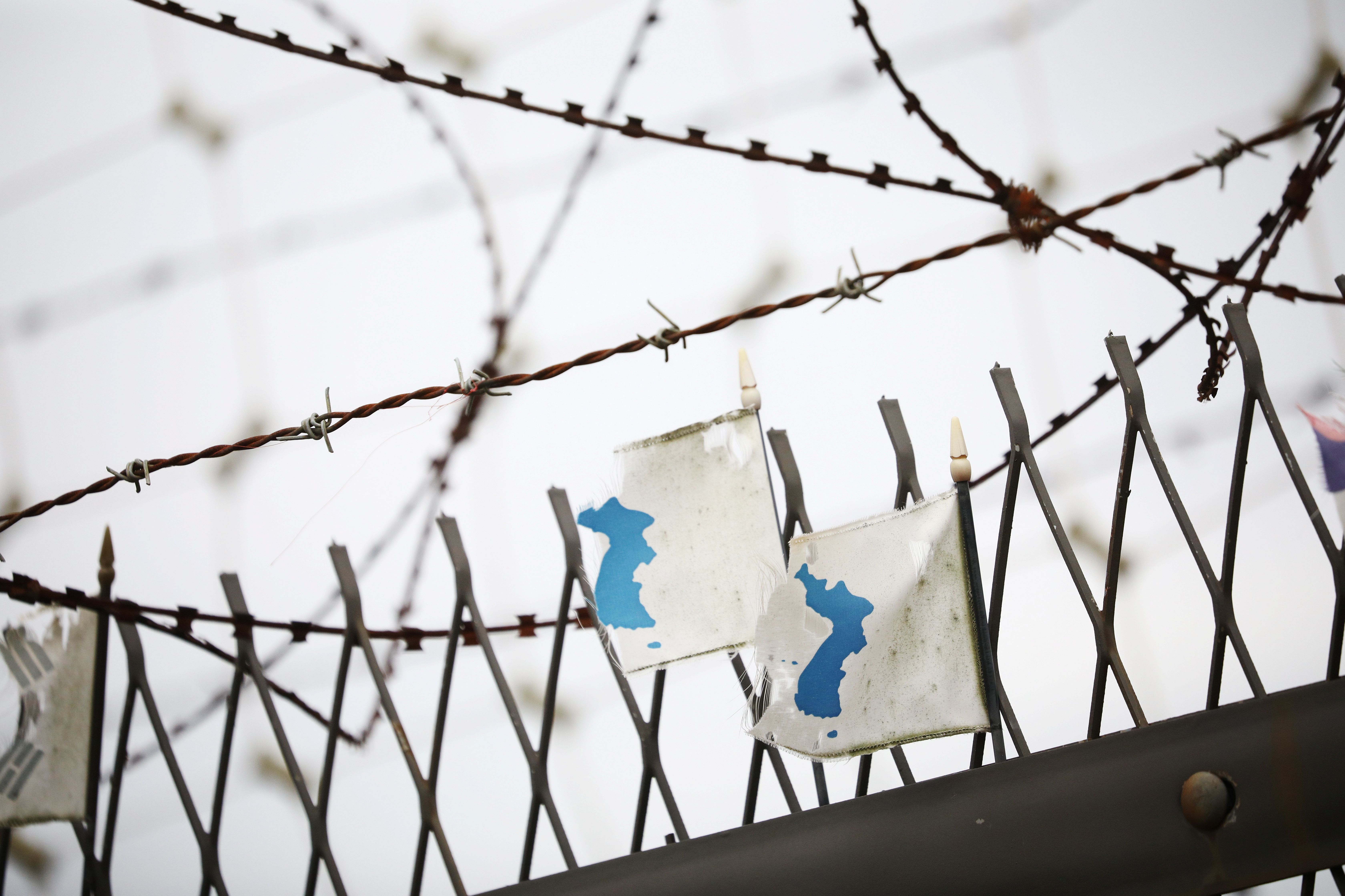 Lõuna-Koreas Pajus 28. juulil 2021. Lõuna-Koreas Pajus asuva demilitariseeritud tsooni läheduses rippuvad tugeva tuulega räsitud Korea ühinemislipud sõjaväeaia ääres. REUTERS/Kim Hong-Ji