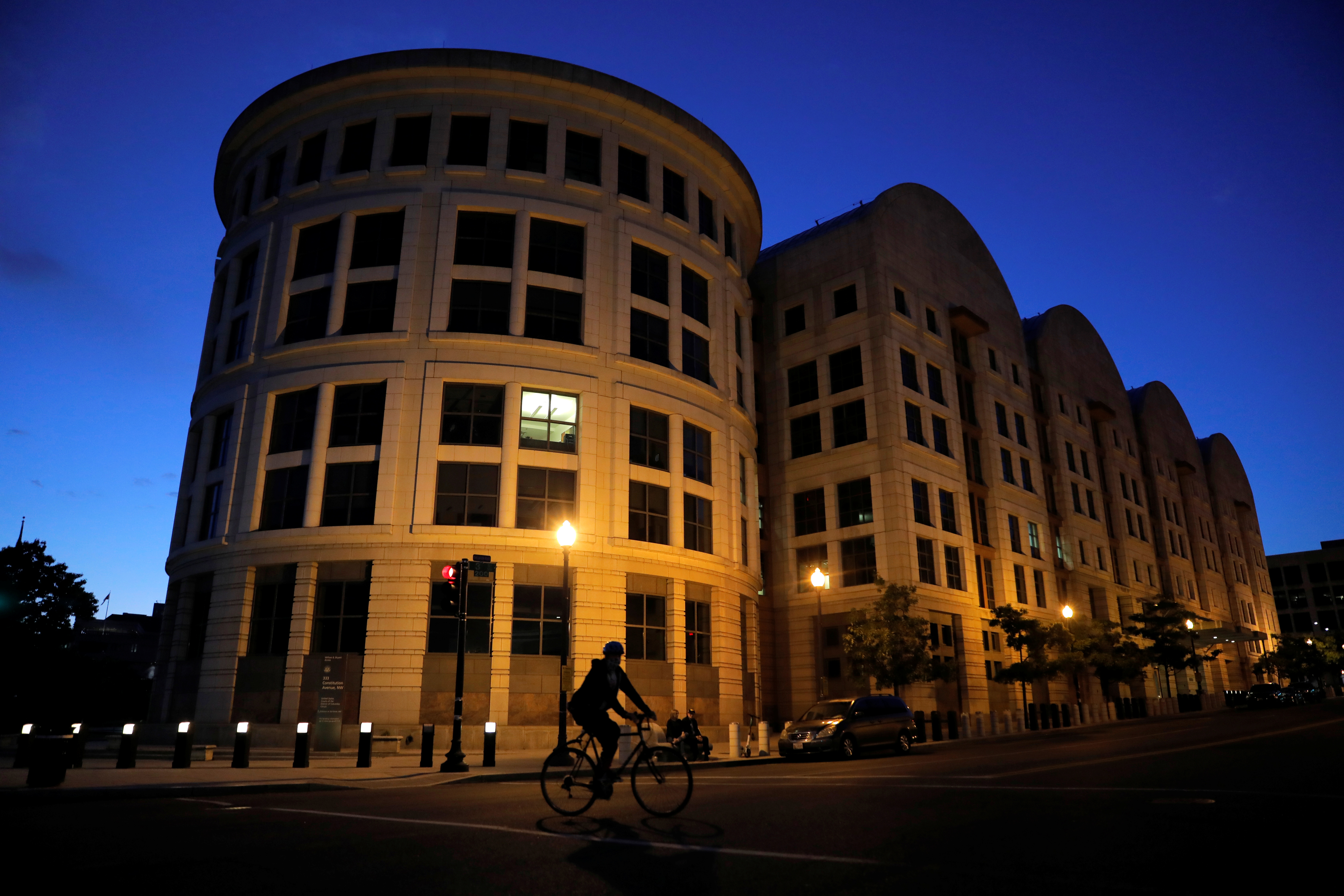 A person rides a bicycle past the U.S. District Court in Washington, D.C.