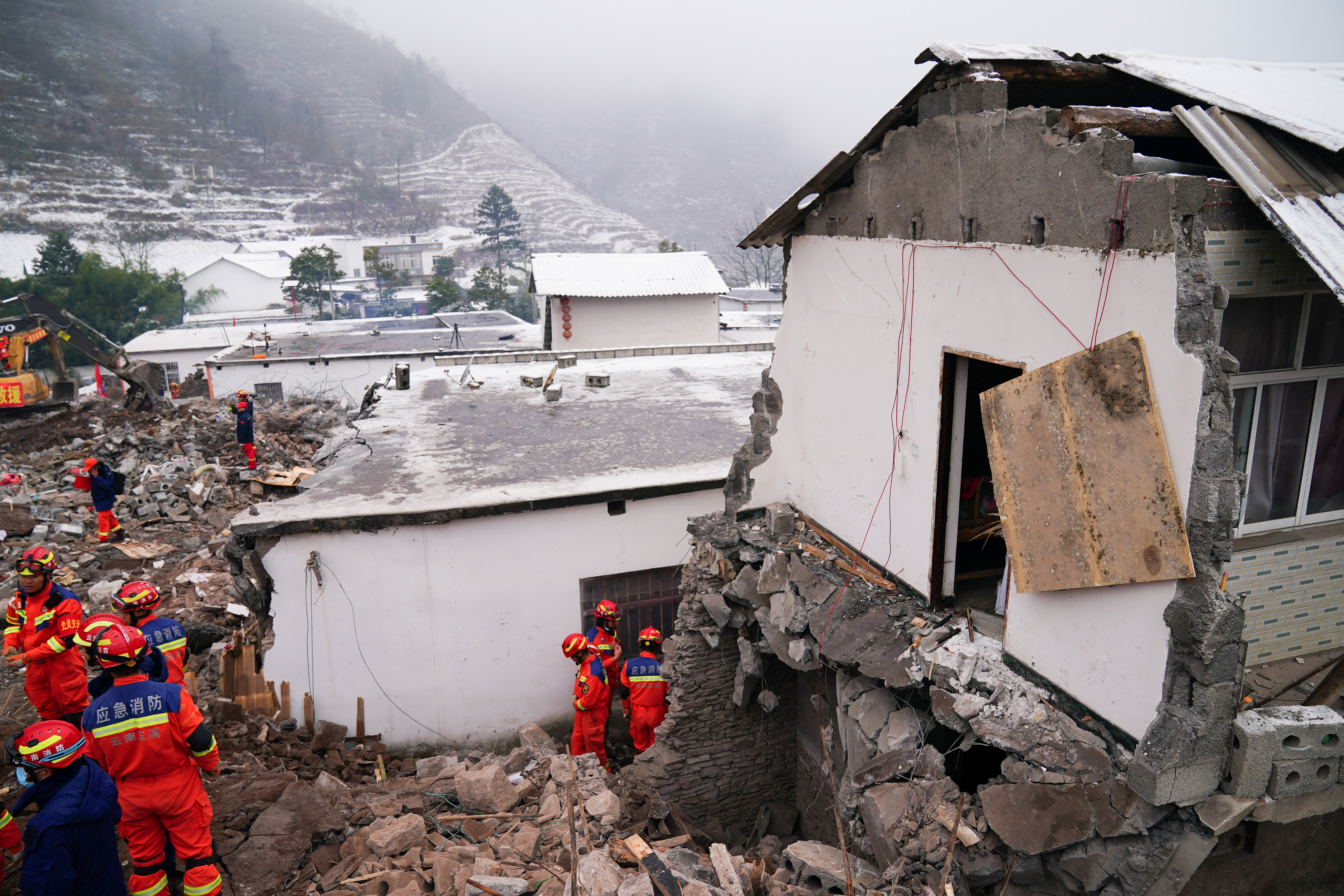 Rescue workers search for survivors near damaged houses after a landslide hit Zhenxiong county in Zhaotong