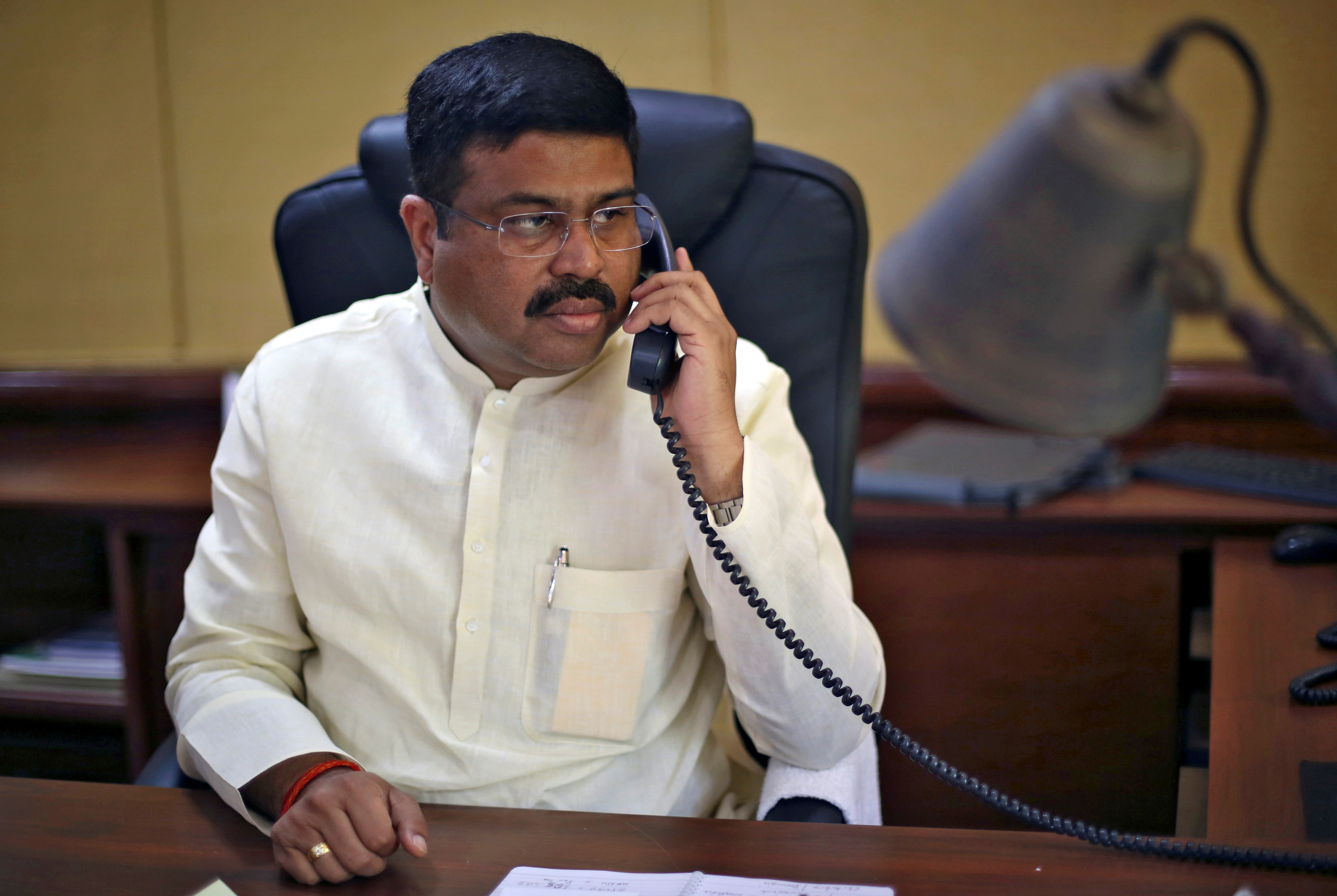 India's Oil Minister Pradhan speaks on phone during an interview with Reuters in New Delhi