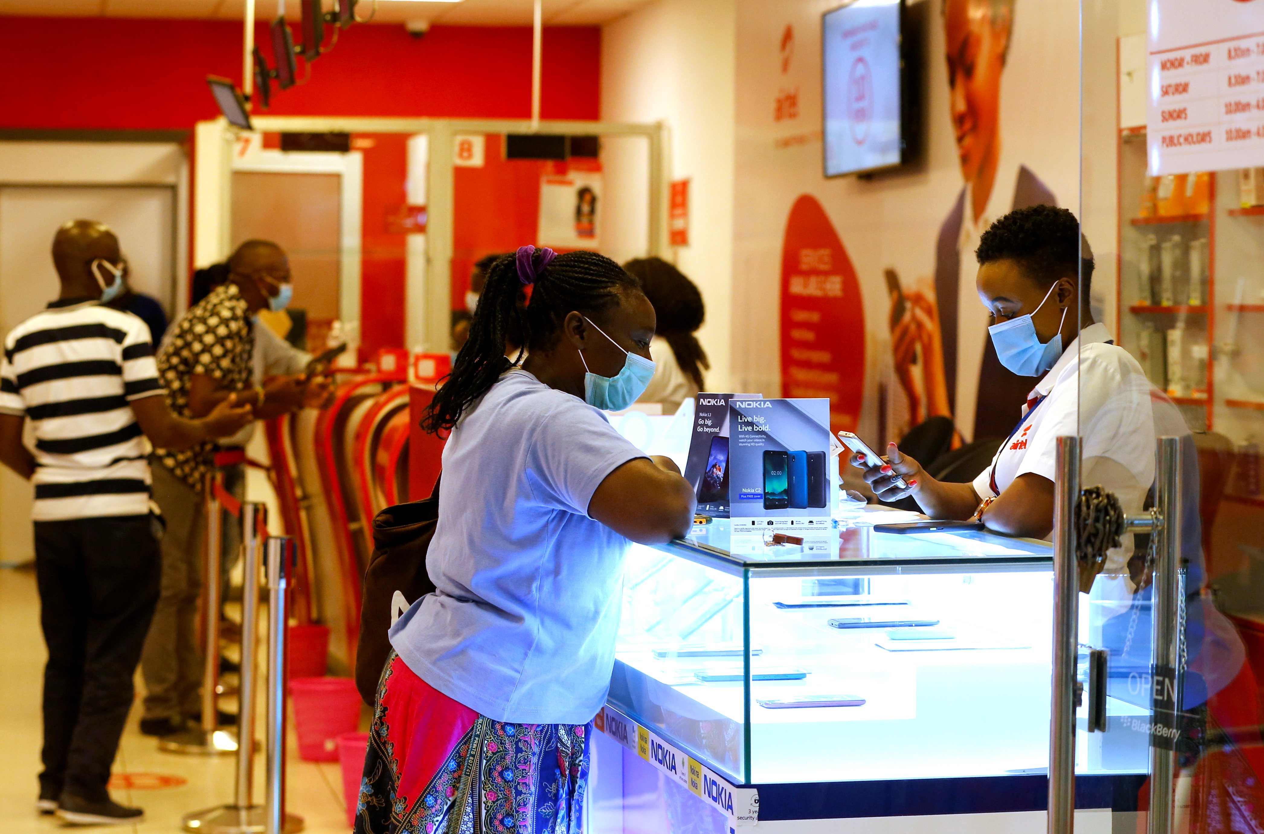 Customers talk to employees inside a mobile phone service centre operated by Kenyan telecom operator Airtel Kenya at the Sarit Centre within the Westlands district of Nairobi