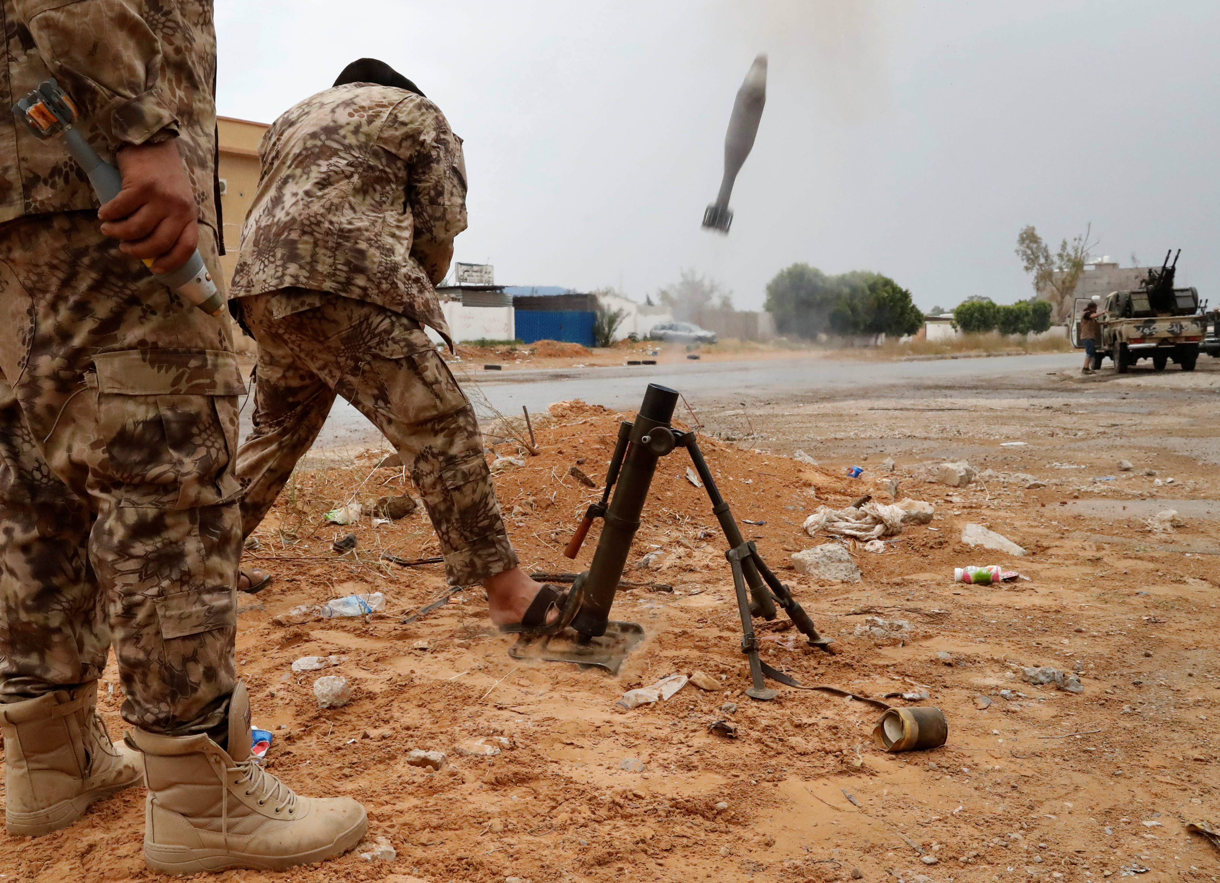 A fighter loyal to Libya's U.N.-backed government (GNA) fires a mortar during clashes with forces loyal to Khalifa Haftar on the outskirts of Tripoli