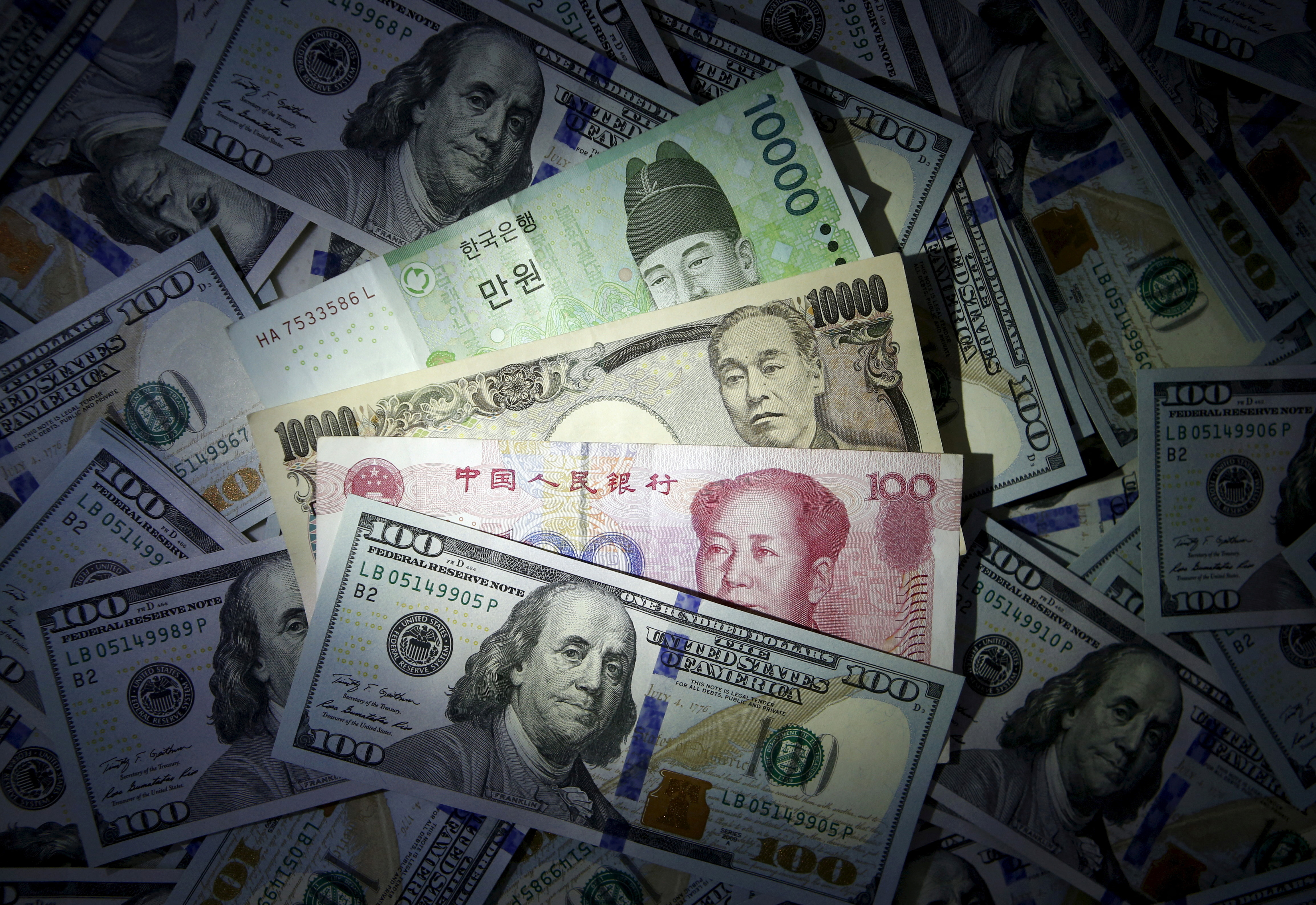 Illustration of South Korean won, Chinese yuan and Japanese yen notes seen on U.S. $100 notes
