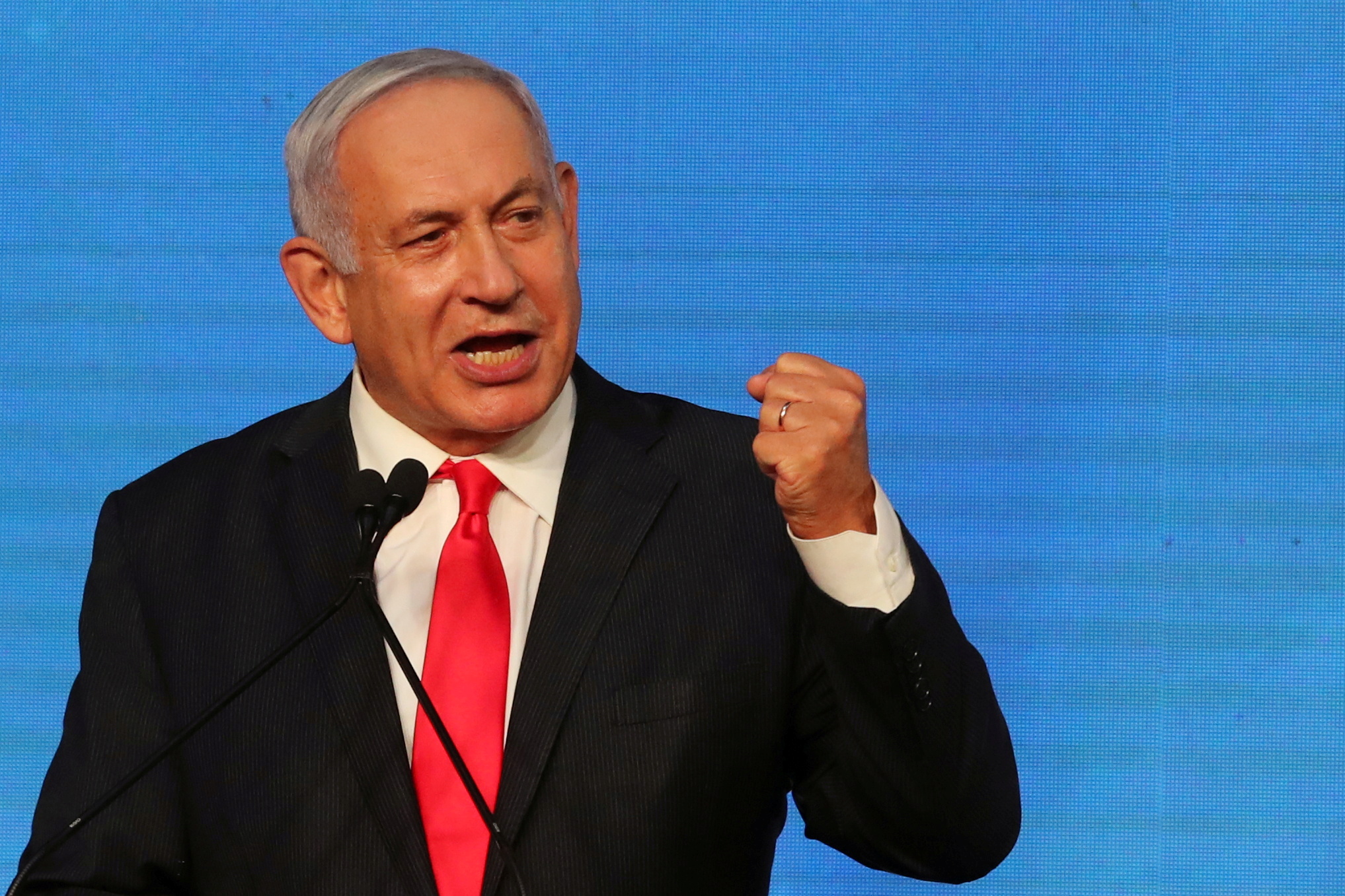 Israeli Prime Minister Benjamin Netanyahu gestures as he delivers a speech to supporters following the announcement of exit polls in Israel's general election at his Likud party headquarters in Jerusalem