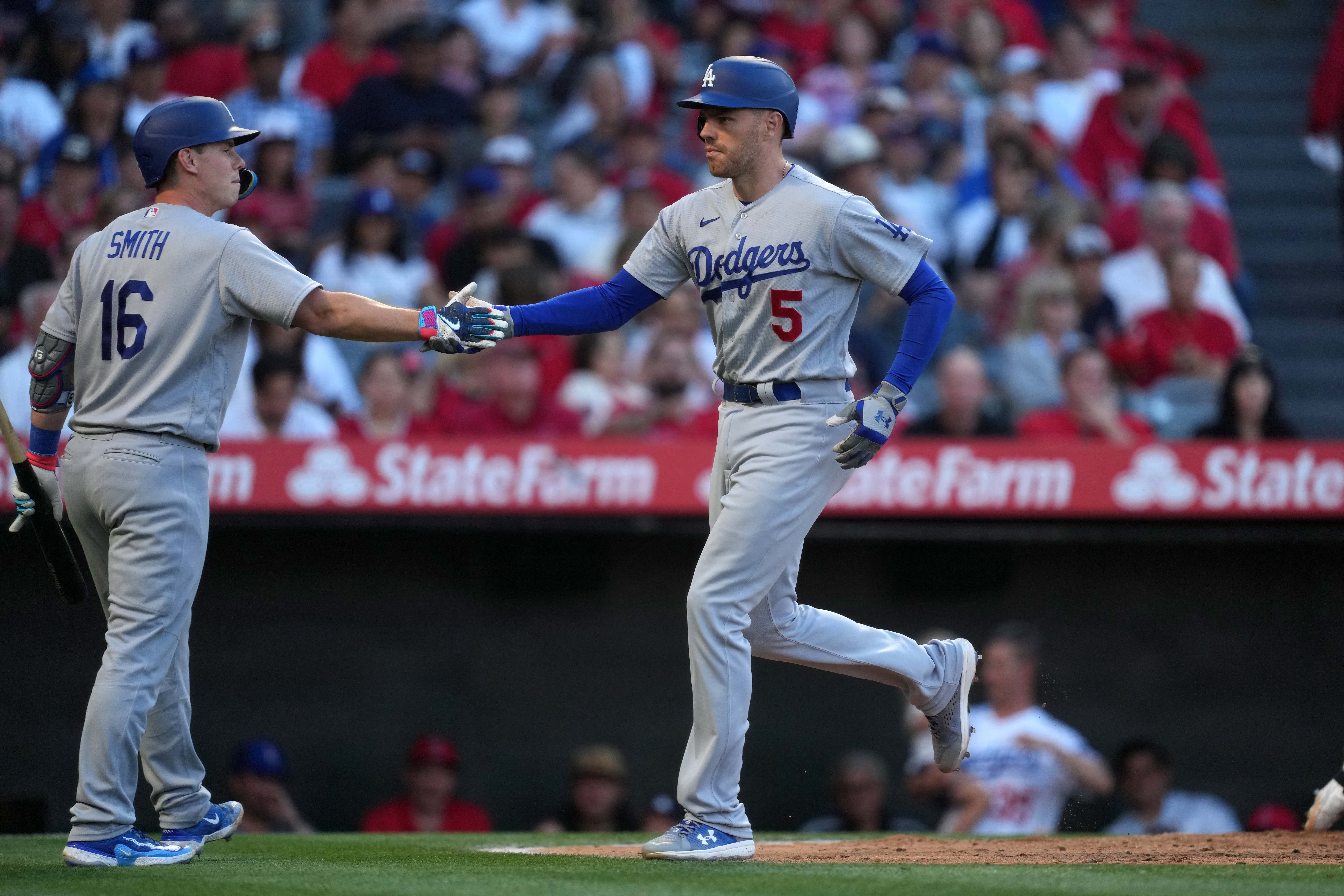 Los Angeles Dodgers' manager Dave Roberts adjusts field positions in the  second inning during the Dodgers home opener agains the Arizona  Diamondbacks at Dodger Stadium in Los Angeles on April 12, 2016.