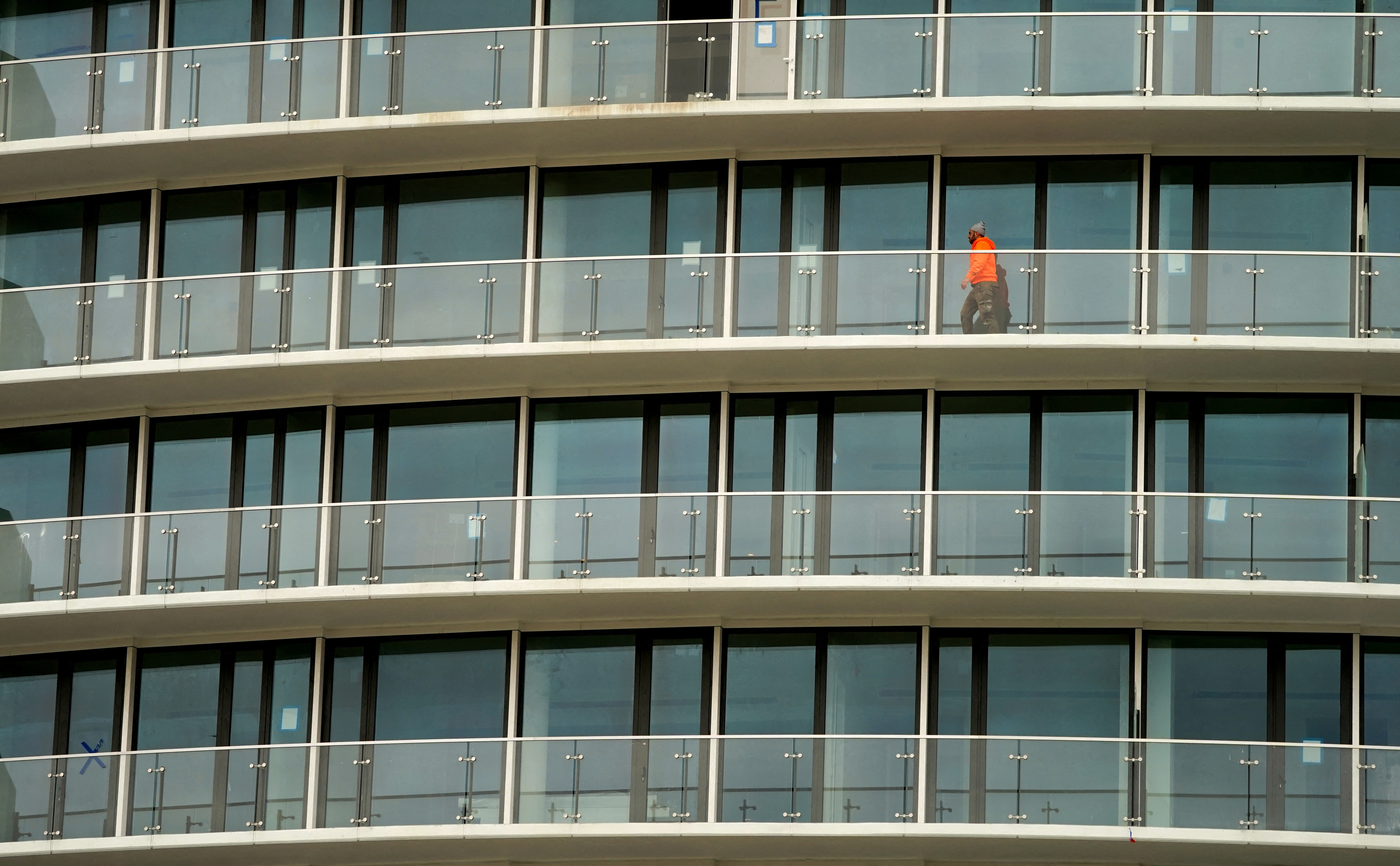 Worker walks along a balcony at The Wharf in Washington