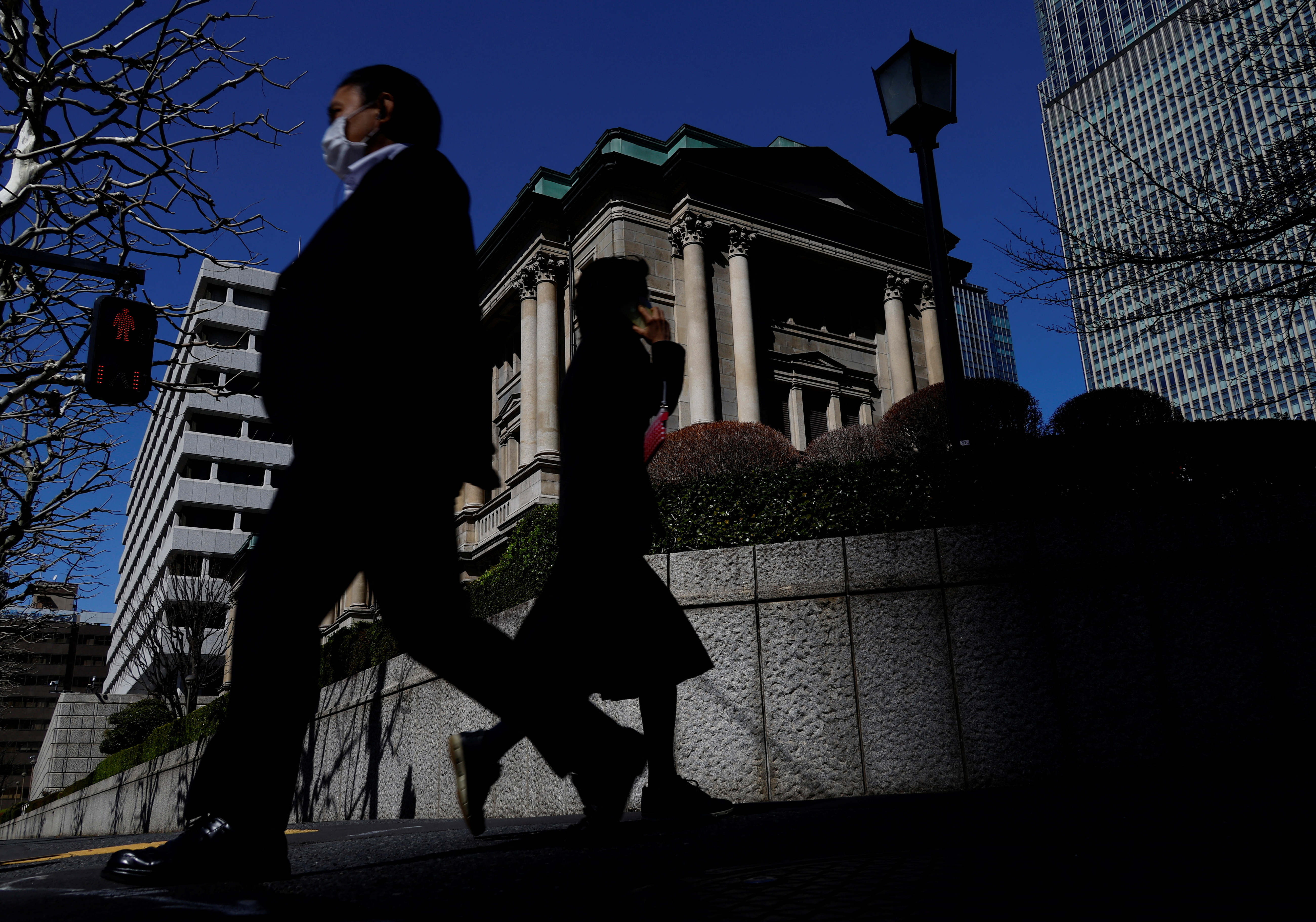 Pedestrians walk past the Bank of Japan building in Tokyo