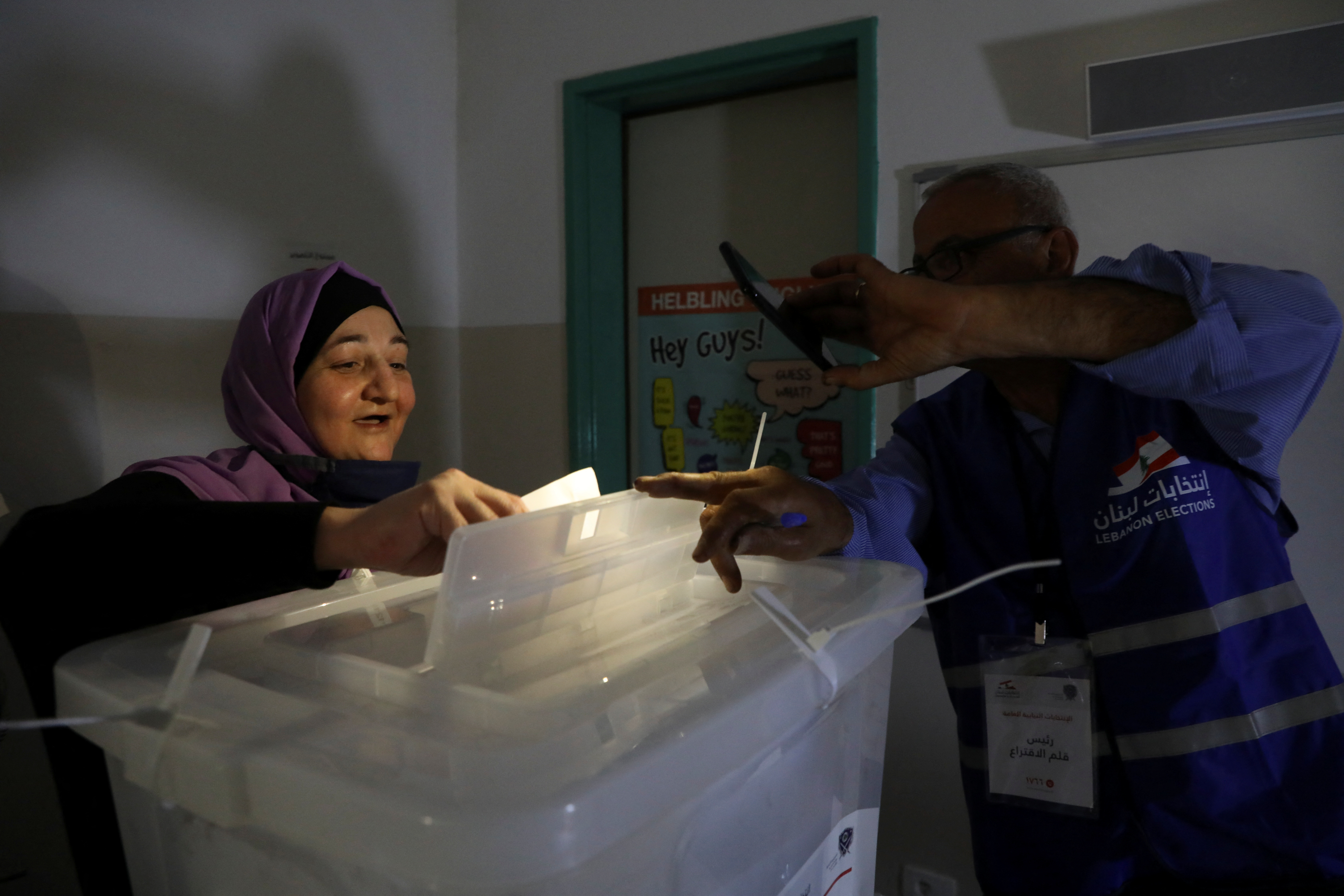 A woman casts her vote at a polling station during a power cut in Lebanon's parliamentary election, in Beirut
