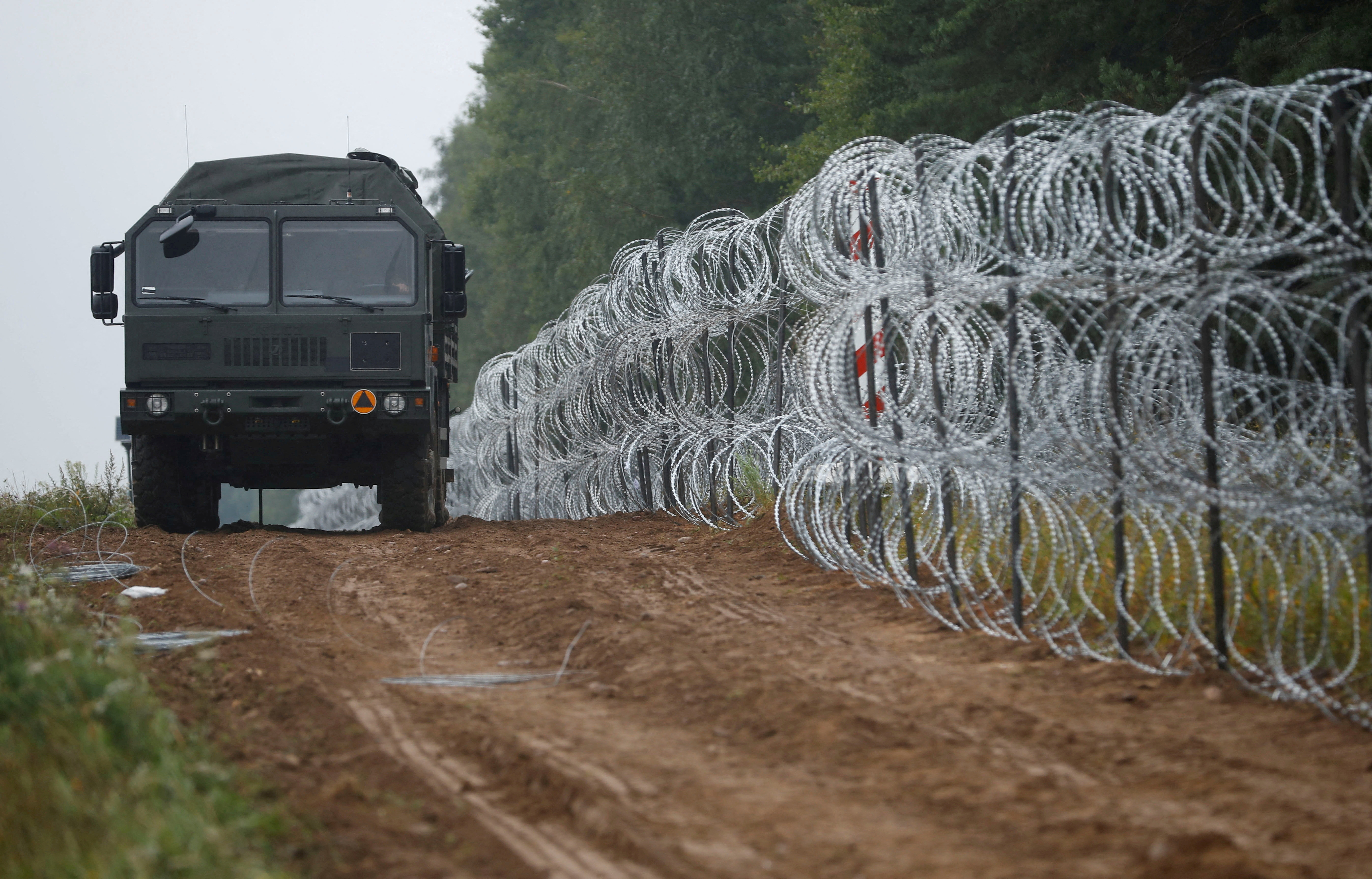 Polish soldiers build a fence on the border between Poland and Belarus near the village of Nomiki