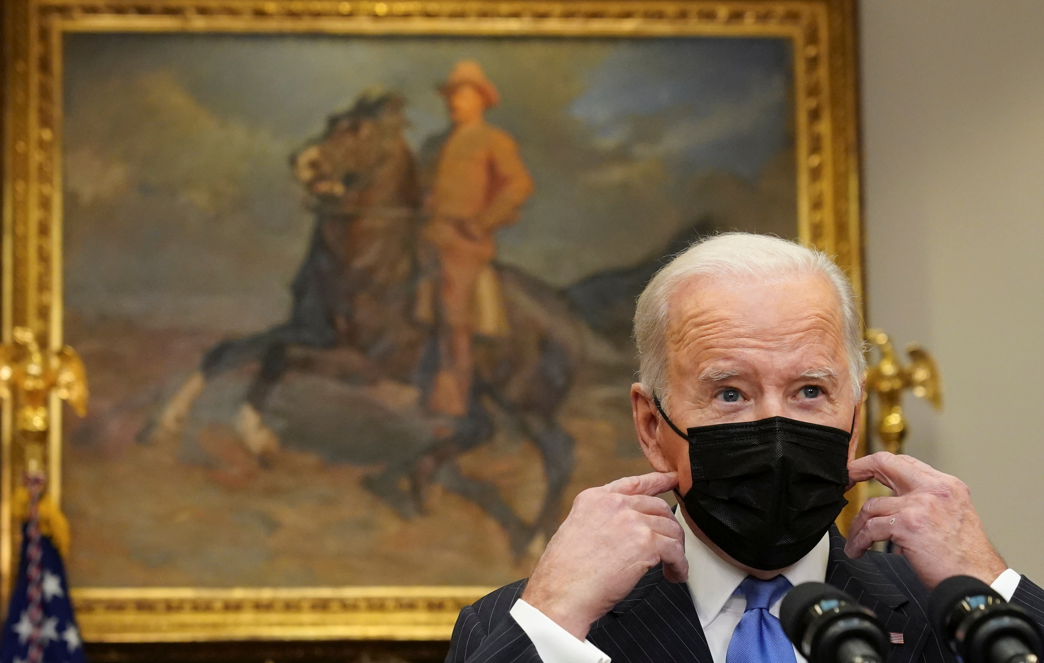 U.S. President Joe Biden removes his mask to deliver an update on the Omicron variant at the White House in Washington, U.S., November 29, 2021. REUTERS/Kevin Lamarque     