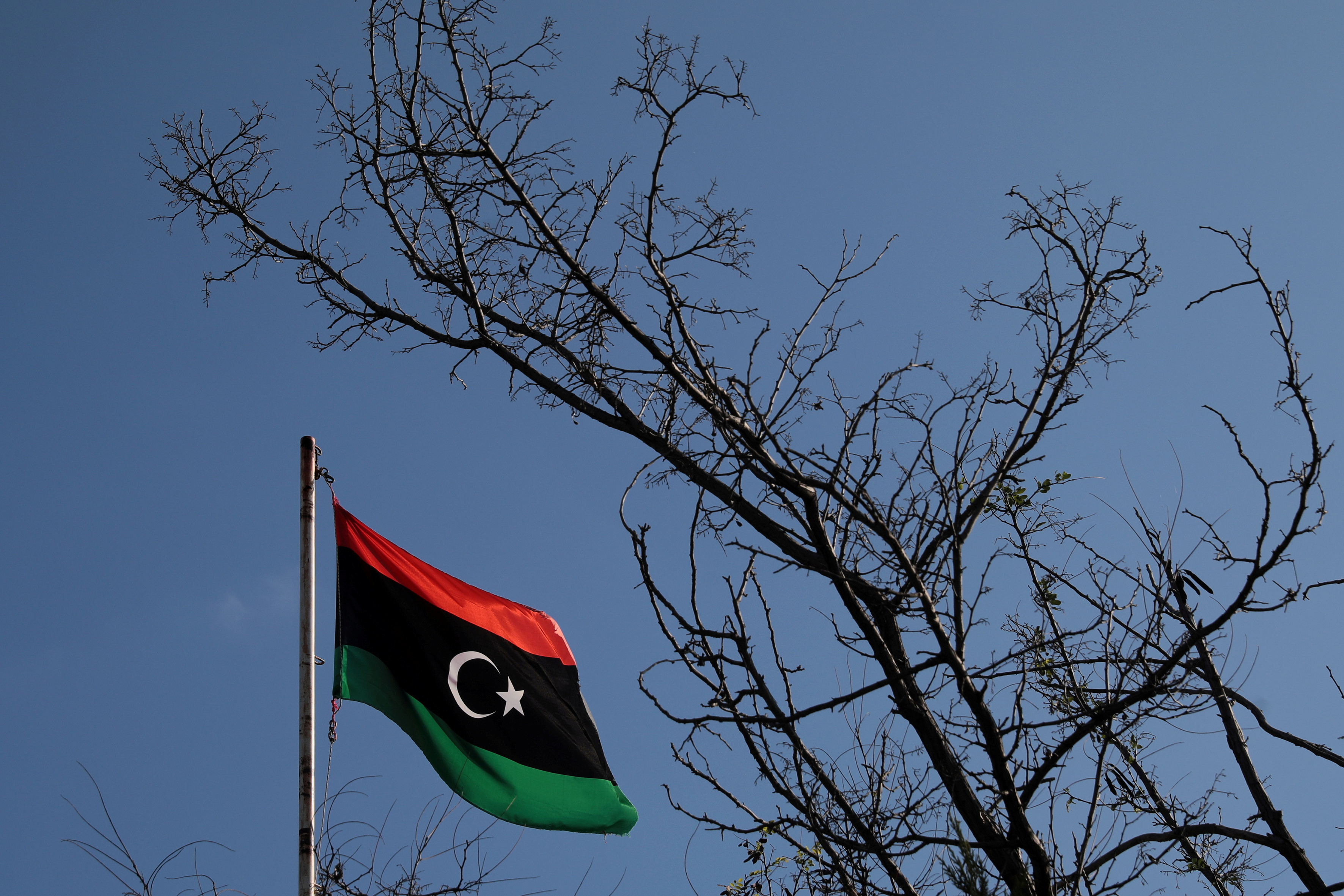 A Libyan flag flutters atop the Libyan Consulate in Athens